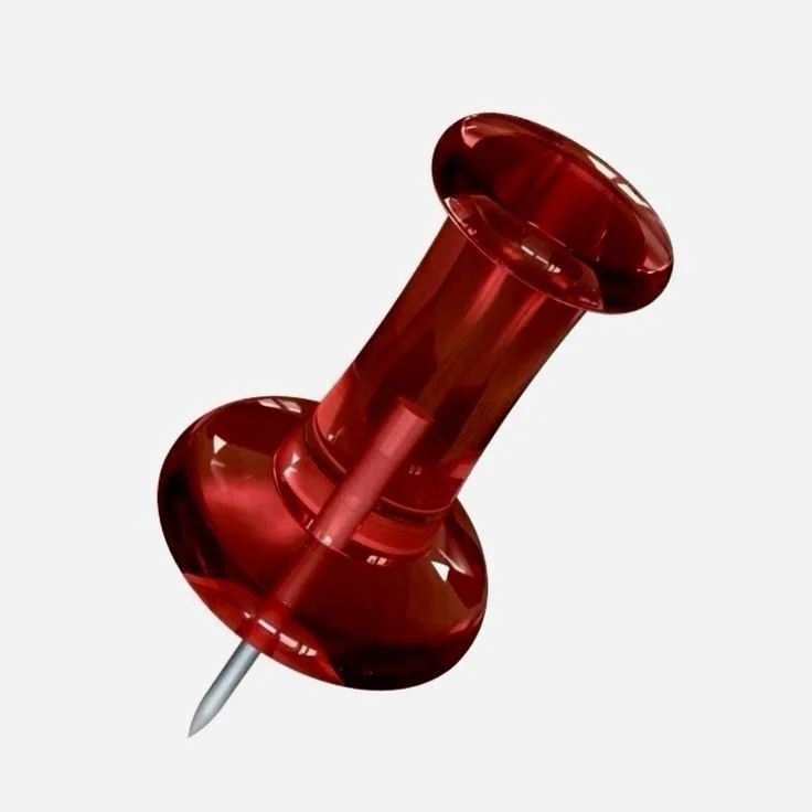 A red translucent push pin with a metal point against a white background.
