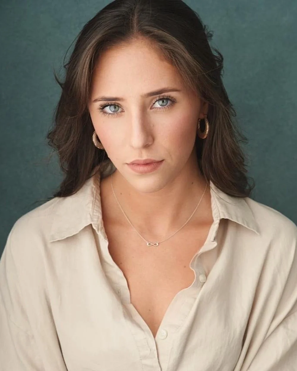 Young woman looking at camera in beige shirt