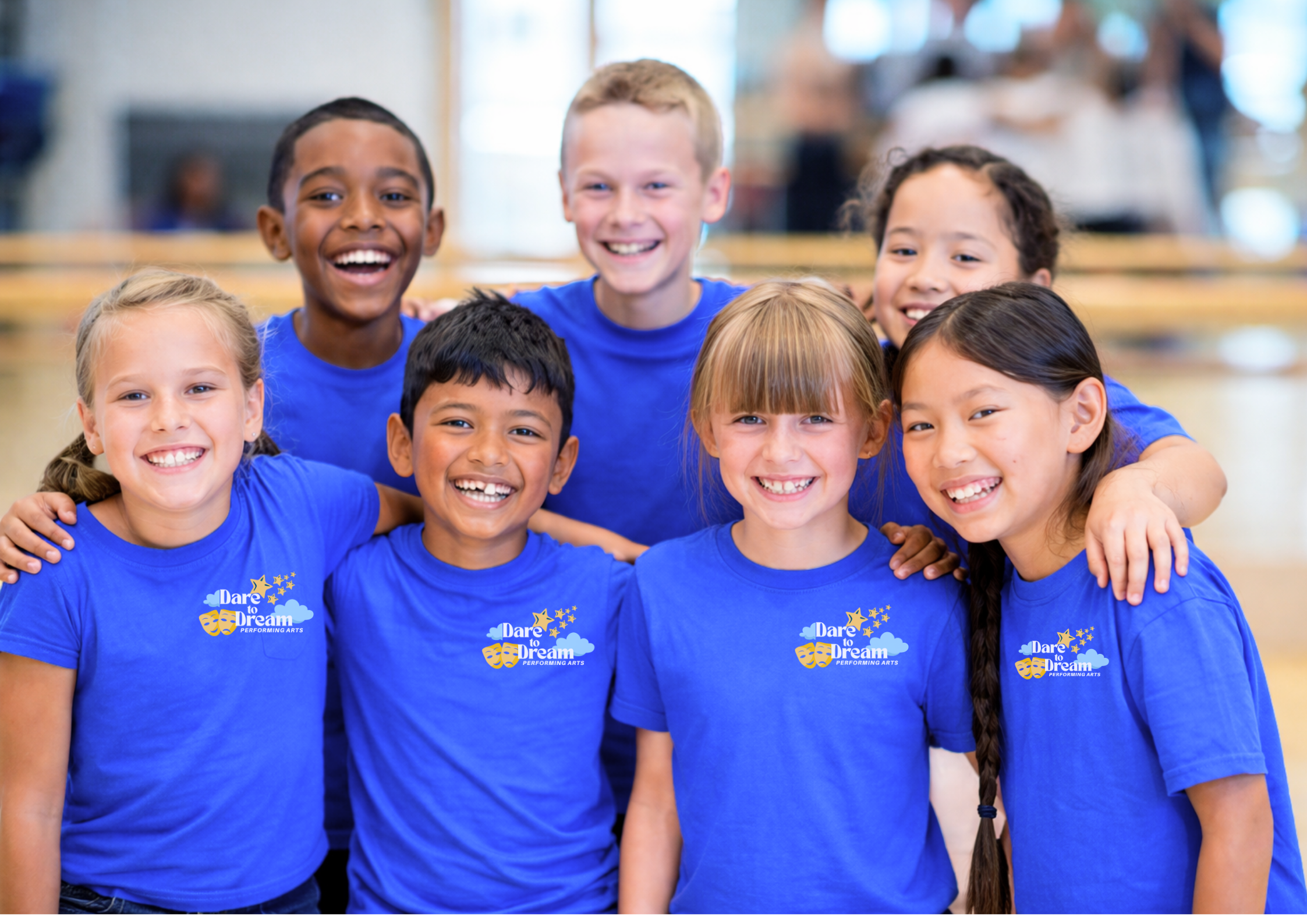 Group of young children smiling in blue dare to dream performing arts tshirts
