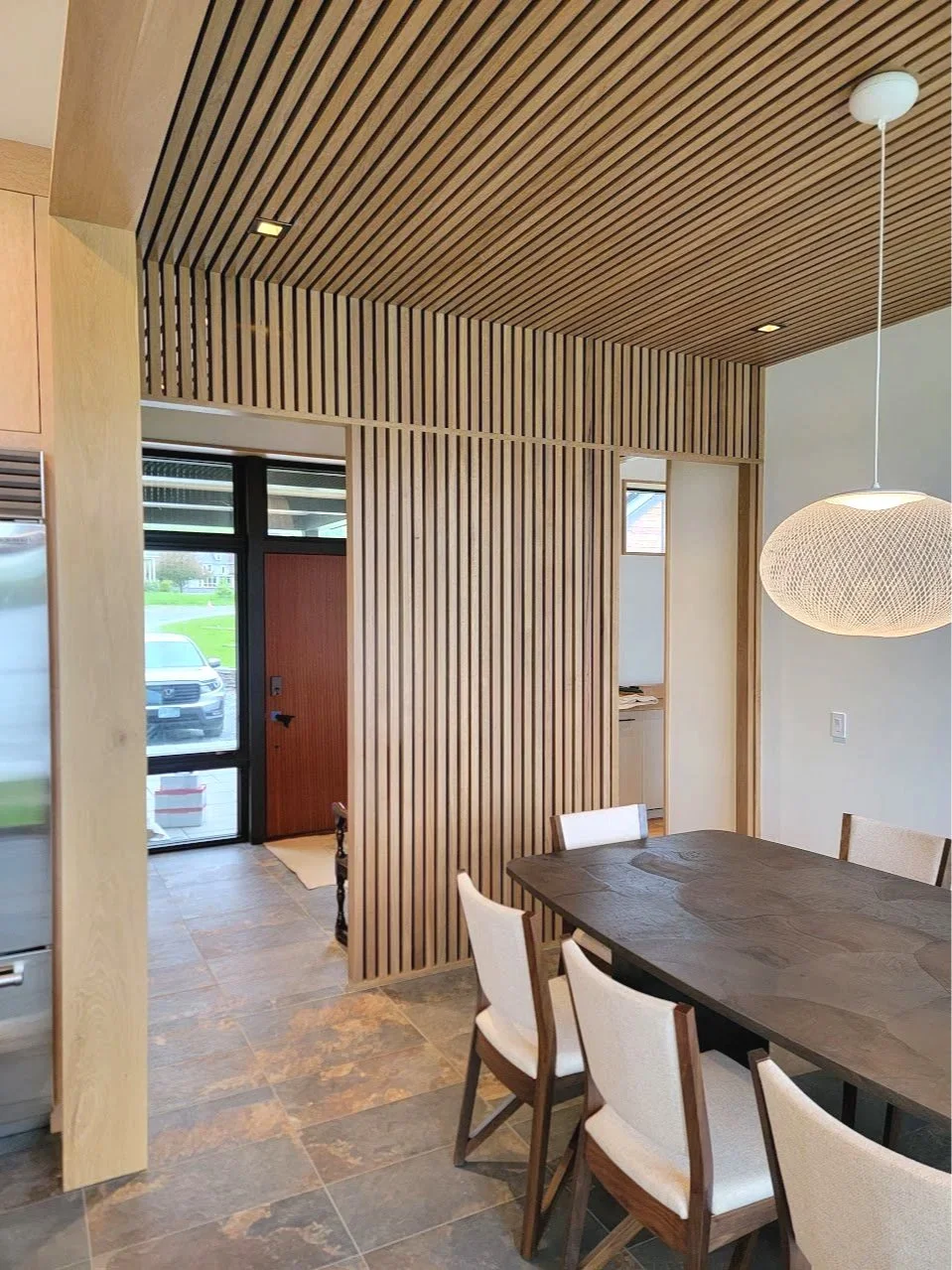 Custom ceiling detail in the dining room, using natural materials to define the space without overpowering it.