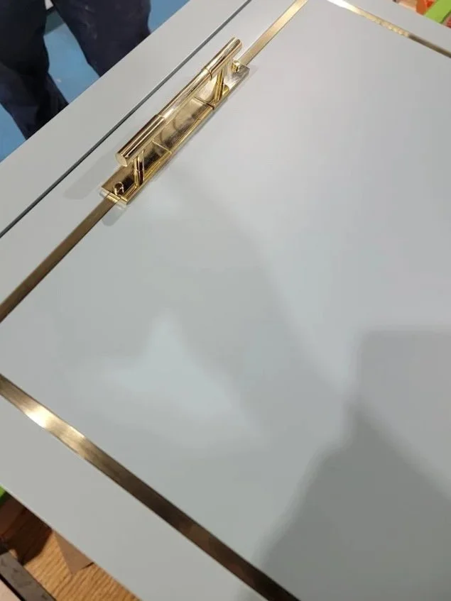 Cabinet door detail featuring precision brass inlay set into custom millwork in the rec room.