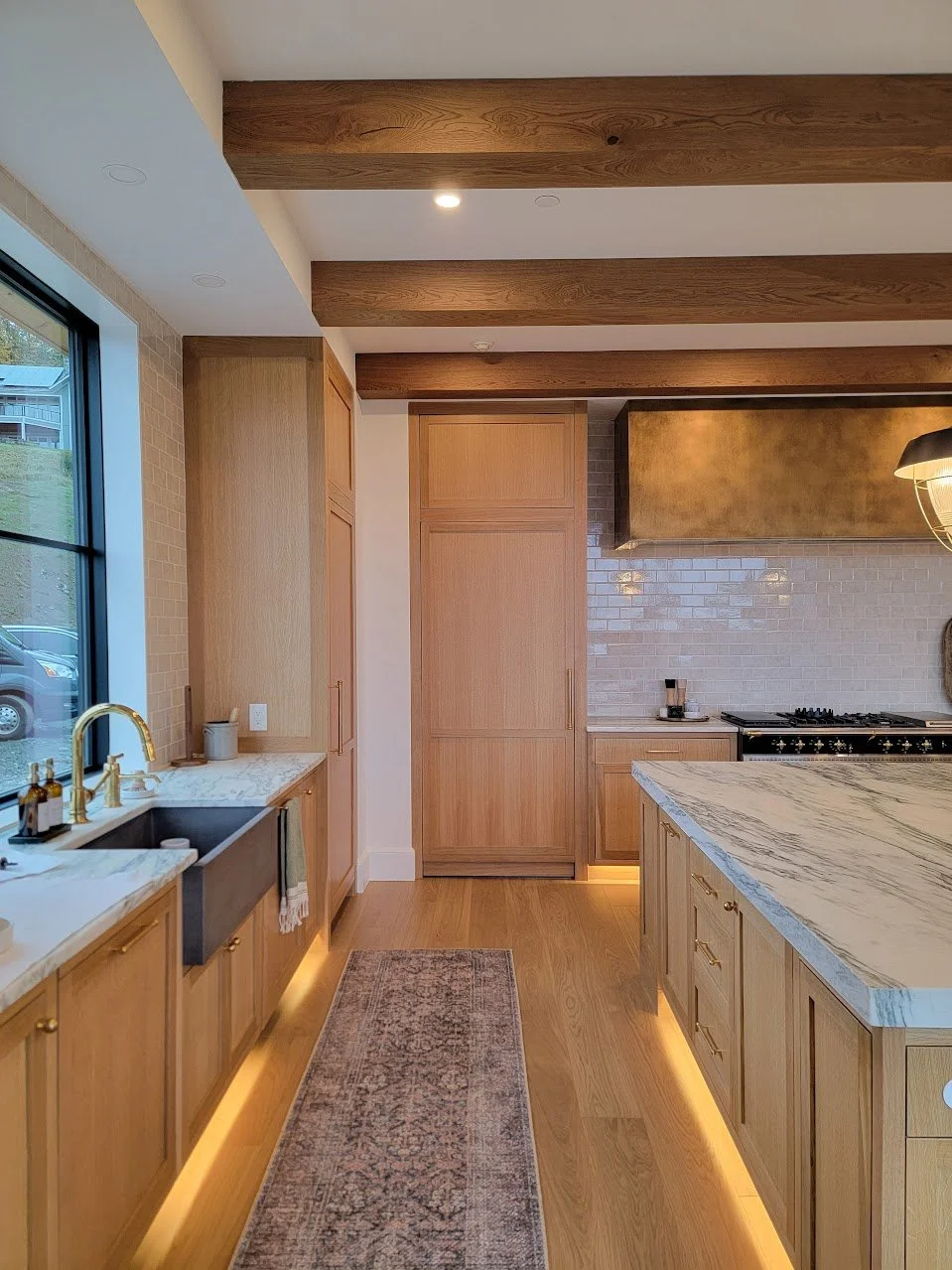Sink wall and concealed pantry door working together to maintain visual continuity while supporting daily use.