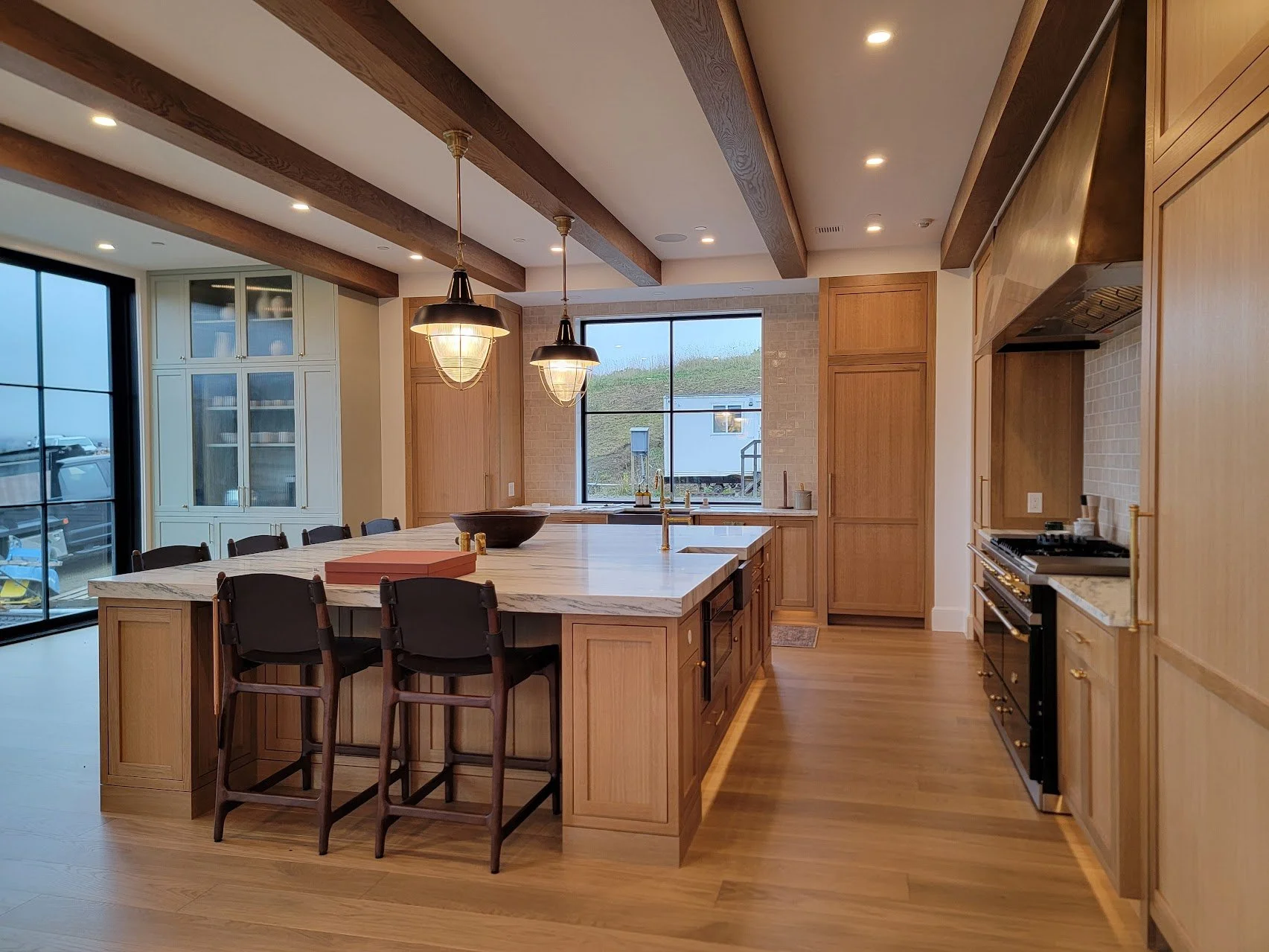 Open kitchen layout featuring panel-ready appliances, stone countertops, and an eight-by-ten-foot island suited for large gatherings.