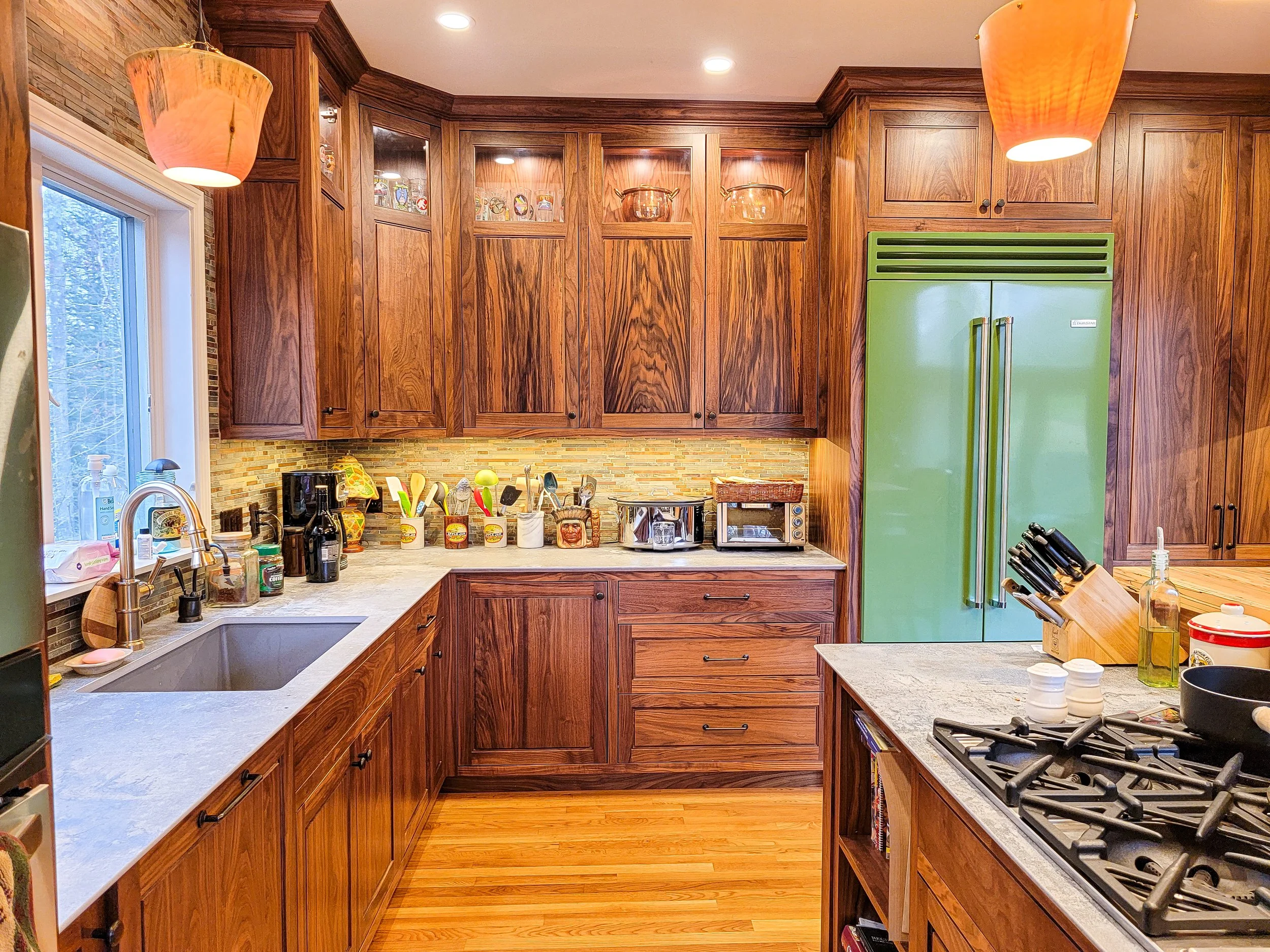 Custom walnut kitchen with inset cabinetry, large island, and built-in appliances in Eastman Community, Grantham NH