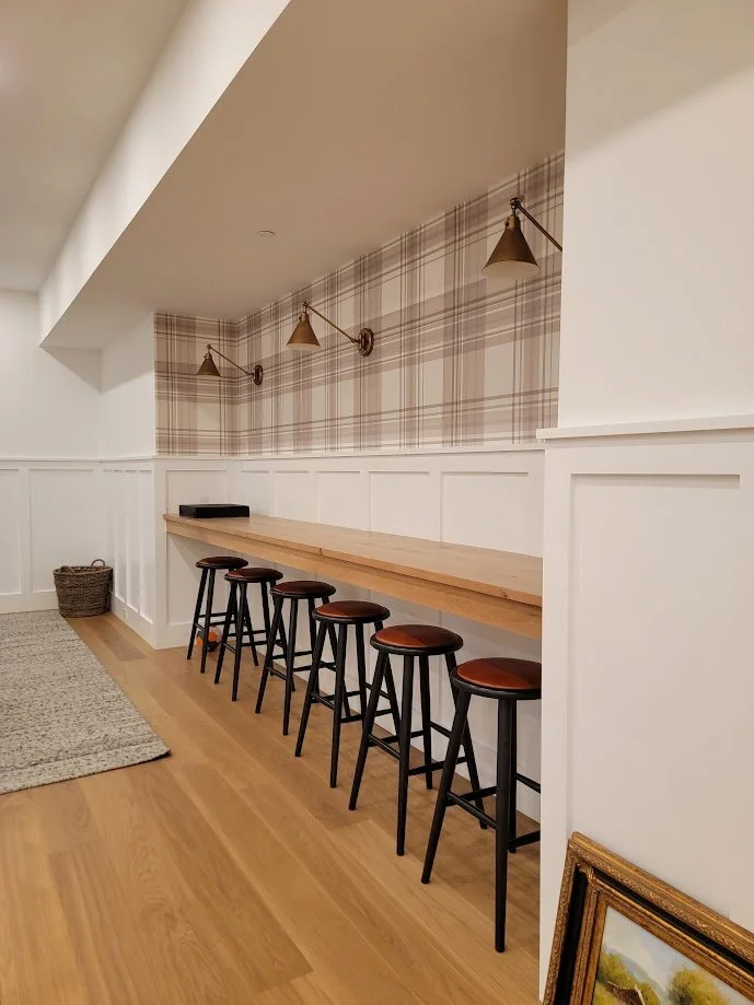 Bar top and surrounding paneling detailed to add warmth and texture while anchoring the space visually.