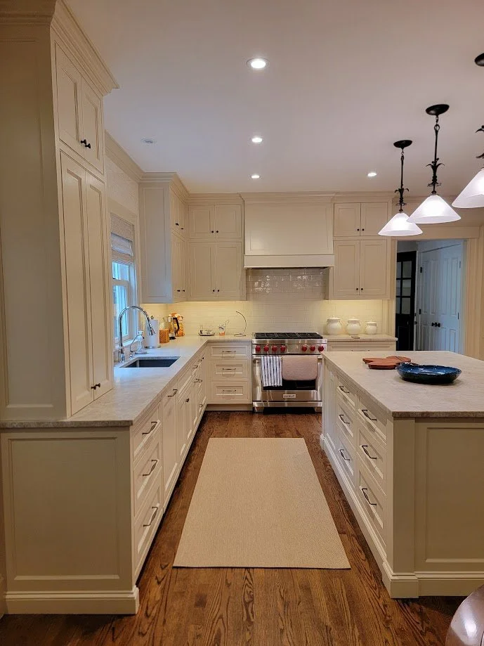 Kitchen cabinetry integrated with surrounding millwork for consistent scale and rhythm.