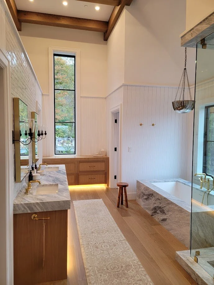 Wall paneling in the primary bathroom adding depth and continuity without overpowering the space.