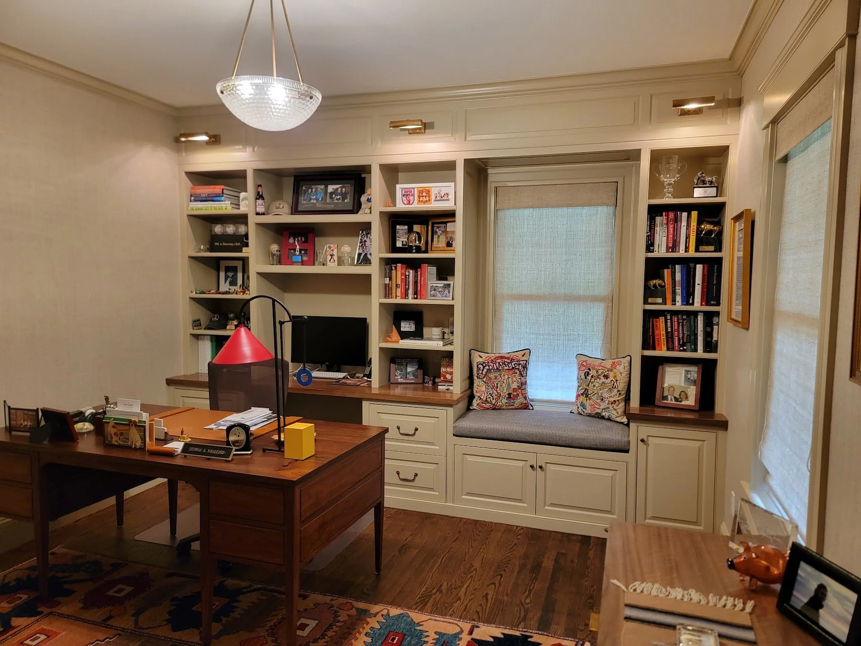 Integrated office millwork combining closed storage and open shelving for a composed, functional workspace.