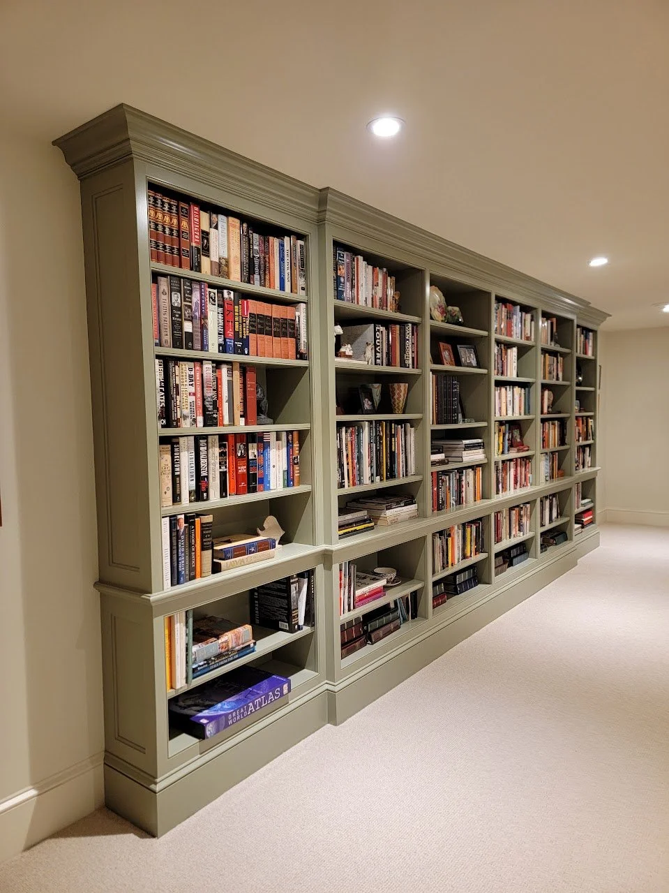 Custom bookcase providing full-height storage while maintaining proportion within the recreation room.