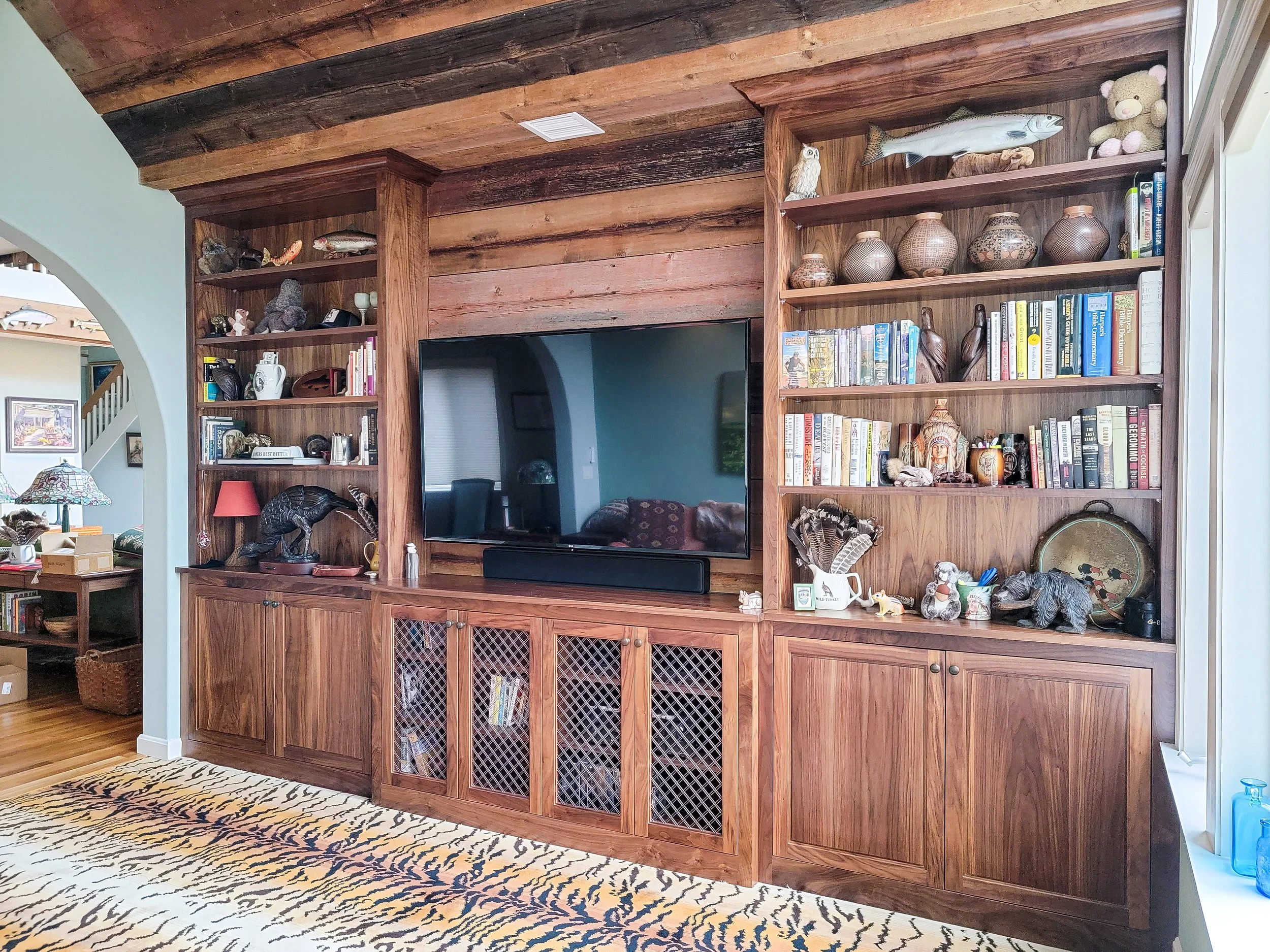 Floor-to-ceiling custom bookcases in walnut with inset cabinetry and open shelving in Grantham NH residence