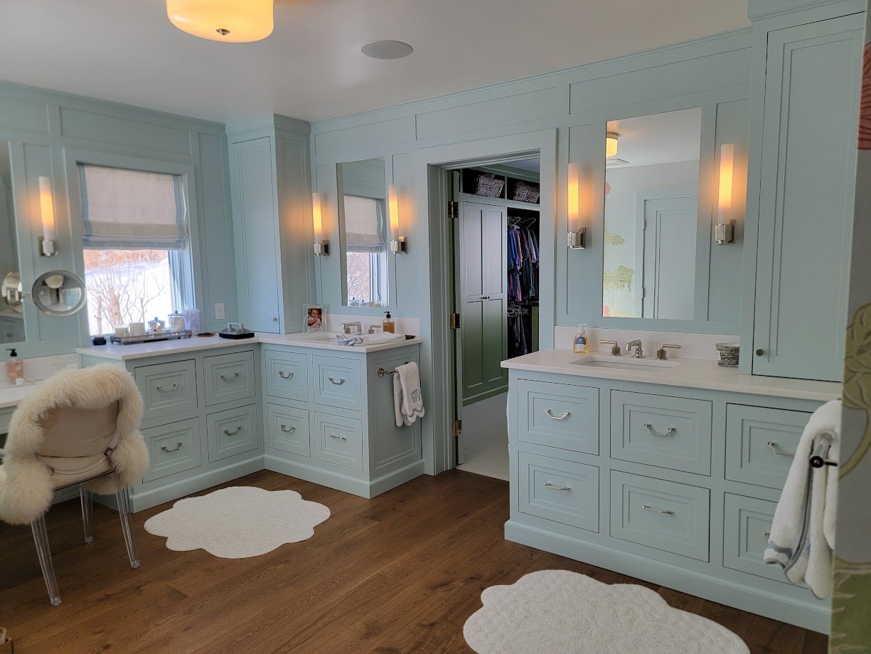 Custom primary bathroom with dual vanities, integrated cabinetry, and cohesive architectural millwork throughout the space.