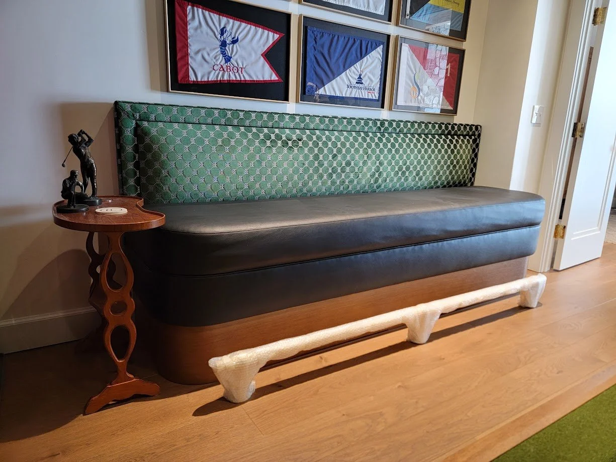 Radius-front upholstered banquette custom built for the golf simulator room, featuring tailored millwork framing and integrated seating within this Quechee Lakes Vermont golf retreat.