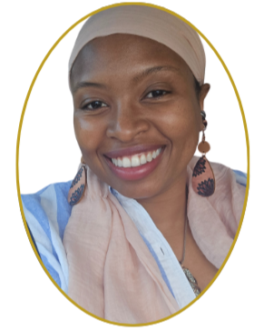 A smiling woman wearing a beige head wrap and earrings, with a white shirt and a beige scarf, against a light background.