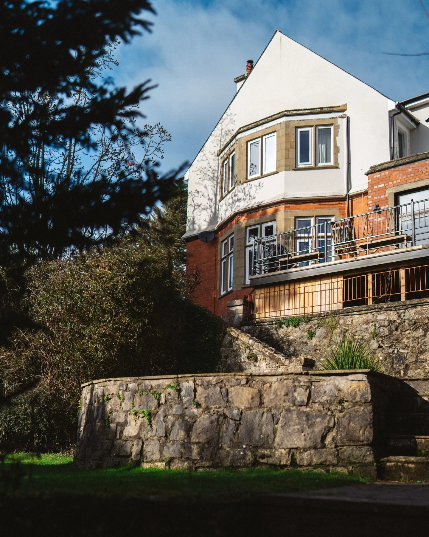 An Arts &amp; Crafts Welsh Manor on the Isle of Anglesey. Thoughtfully restored. Five acres of private garden and woodland, with sweeping views across the Menai Strait to the Eryri mountain range beyond. Space for up to sixteen. Link in bio to check 