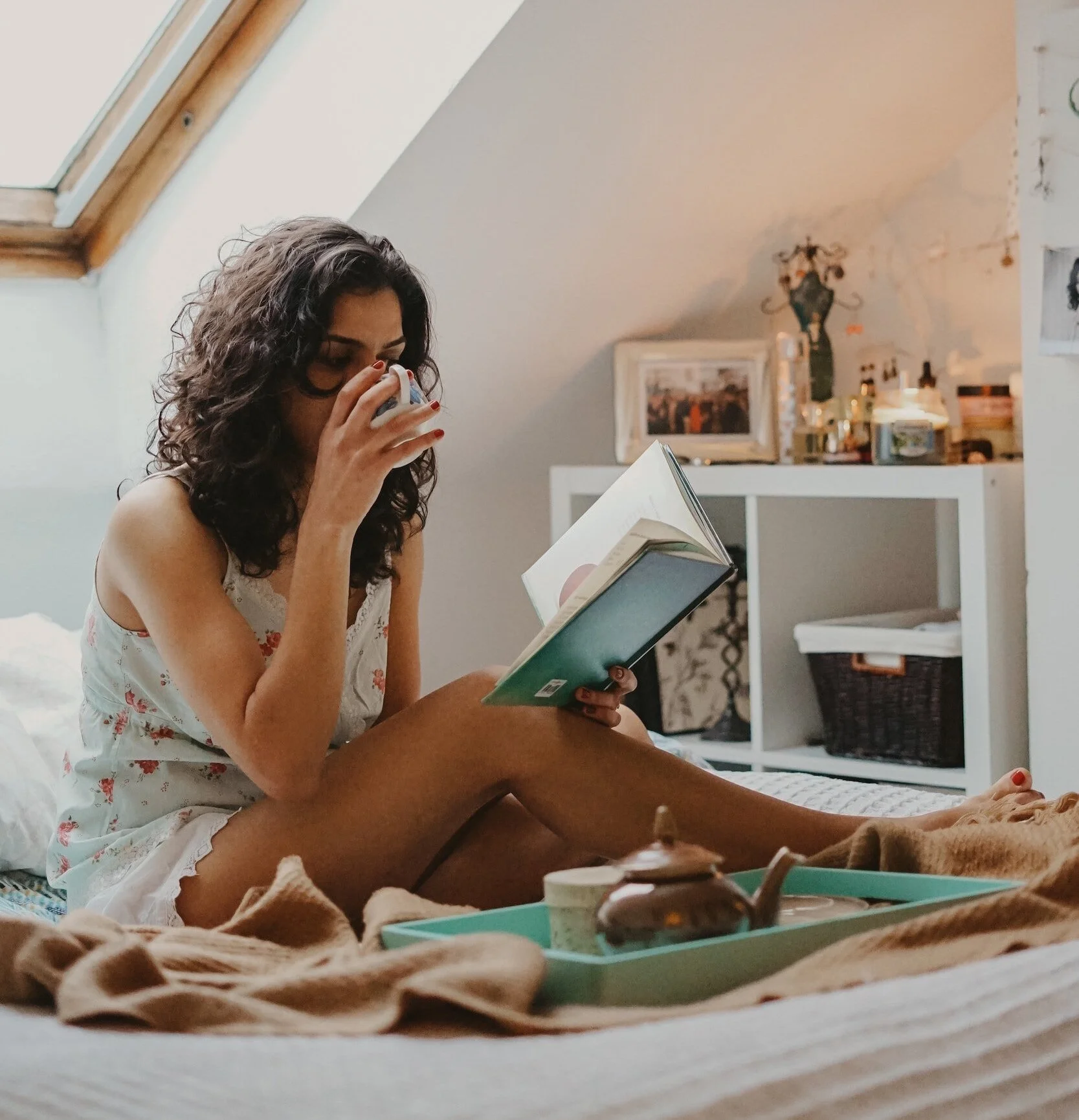 Woman sitting in bed reading a book.