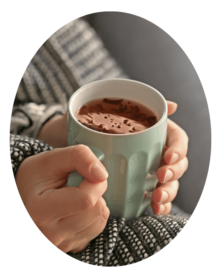 close up of hands holding warm drink.