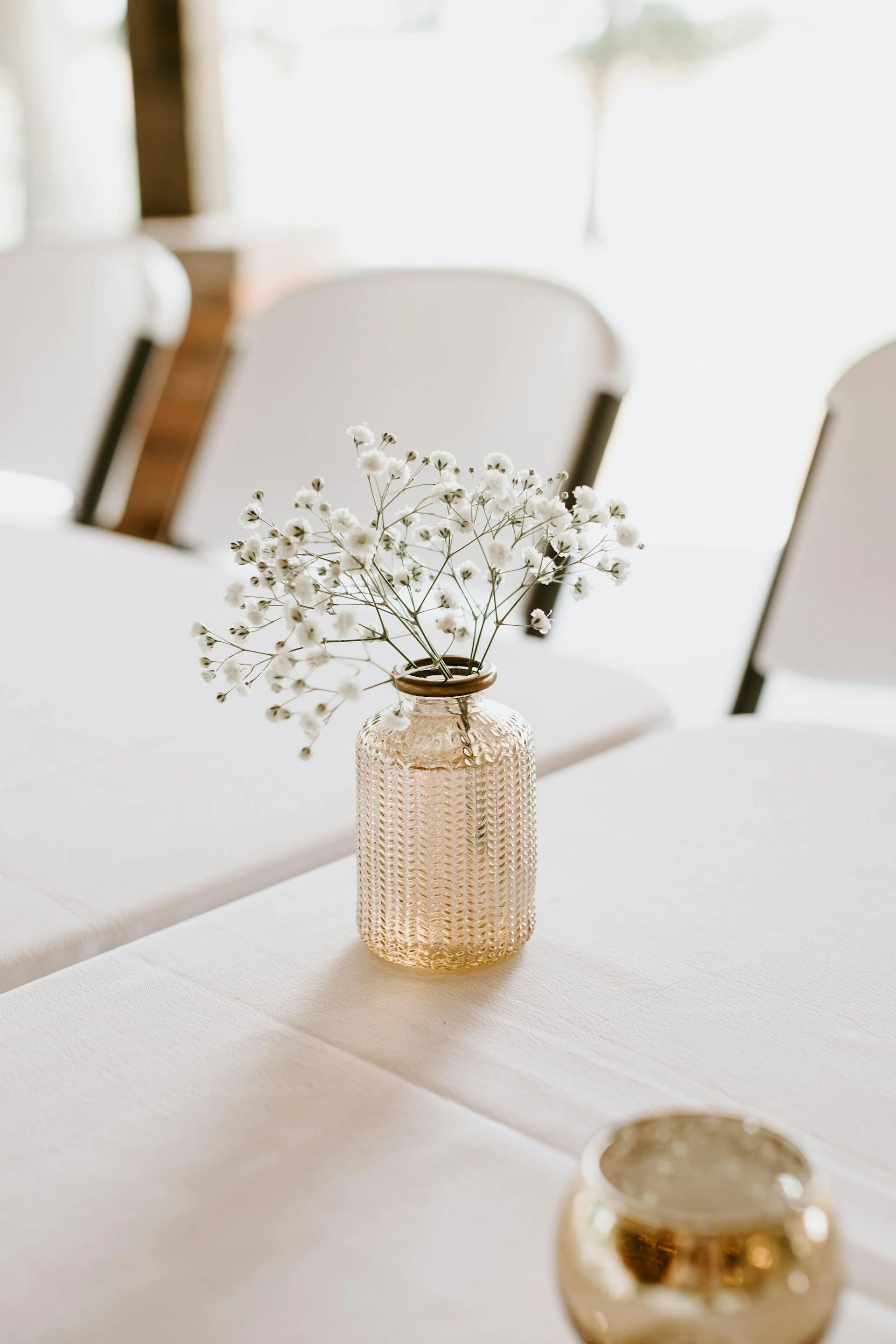 a brown bud vase with flowers.