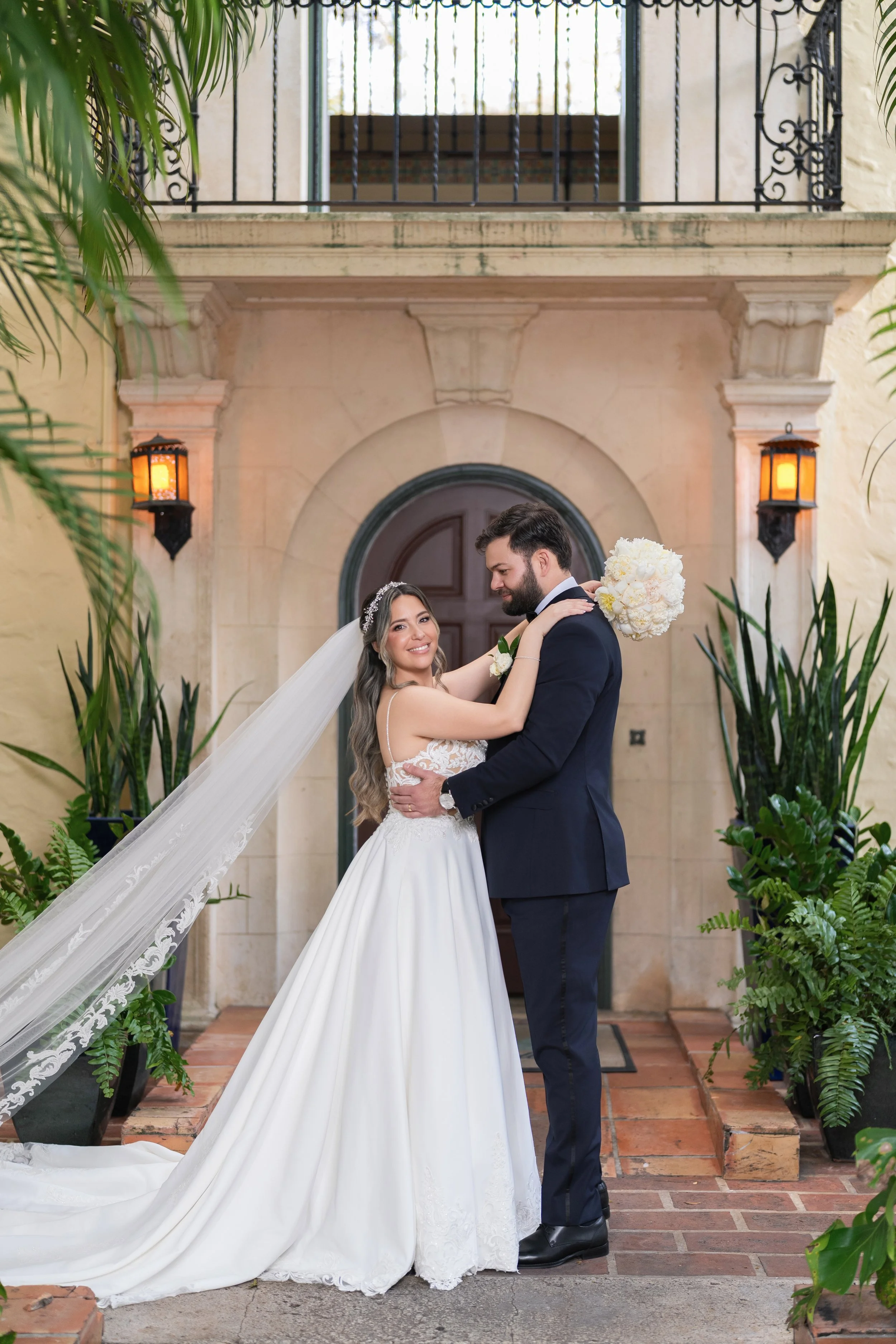 Sophisticated bride and groom portrait at the historic Mediterranean entrance of Villa Woodbine; fine art wedding photography by Star Visual Art, Miami.