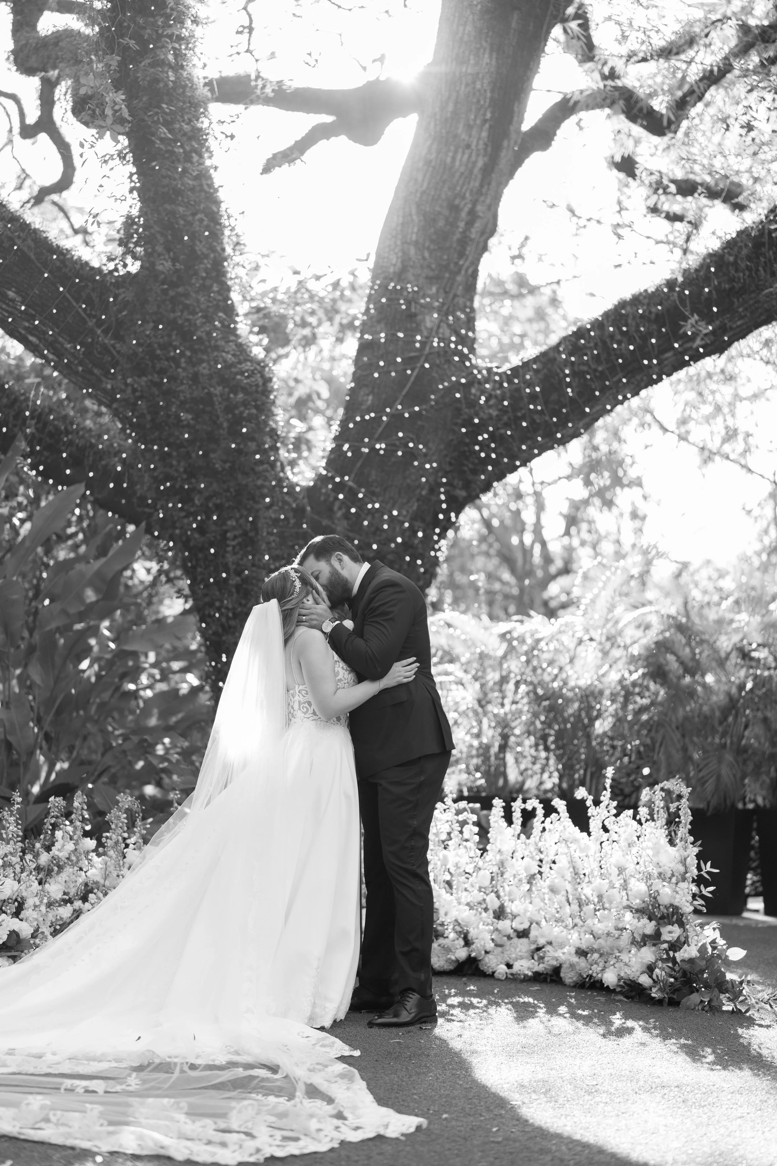 Intimate black and white wedding portrait framed by the historic Banyan tree branches at Villa Woodbine; fine art photography by Star Visual Art, Miami.