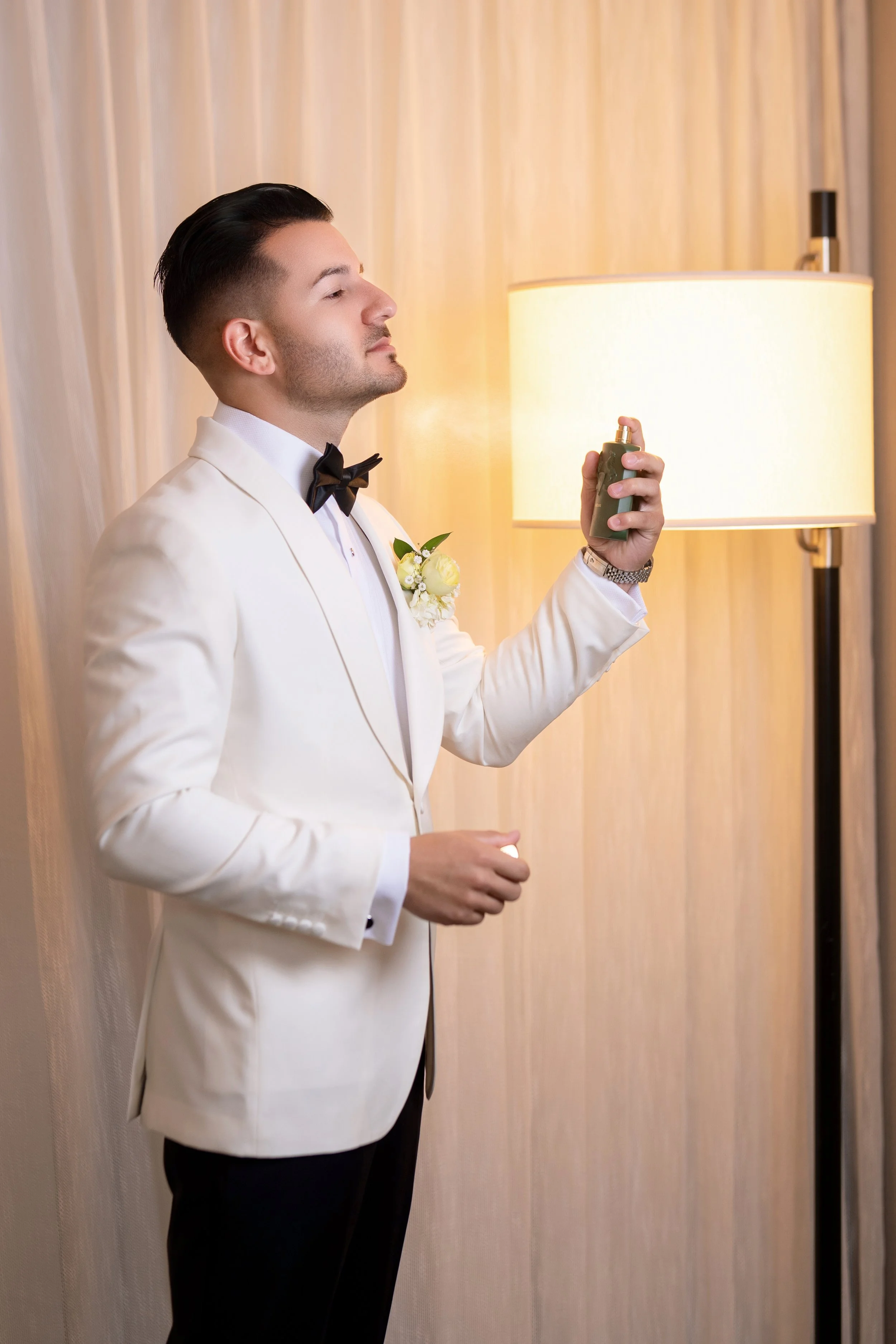 Classic groom portrait in a white tuxedo at HILTON TAMPA DOWNTOWN; fine art wedding photography by Star Visual Art, Tampa.