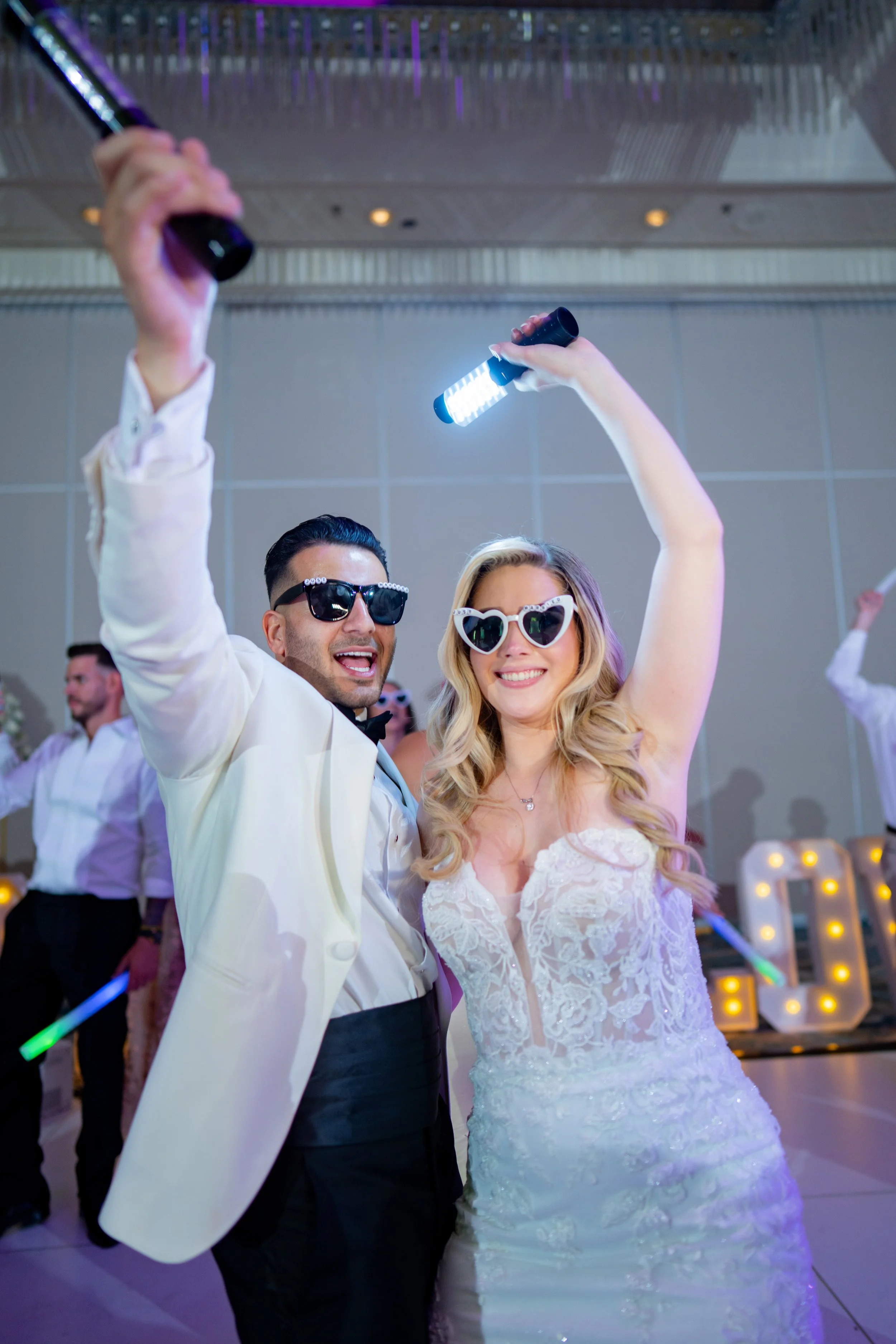 Groom celebrating with friends and party props at HILTON TAMPA DOWNTOWN; fun wedding reception party photography by Star Visual Art, Tampa.
