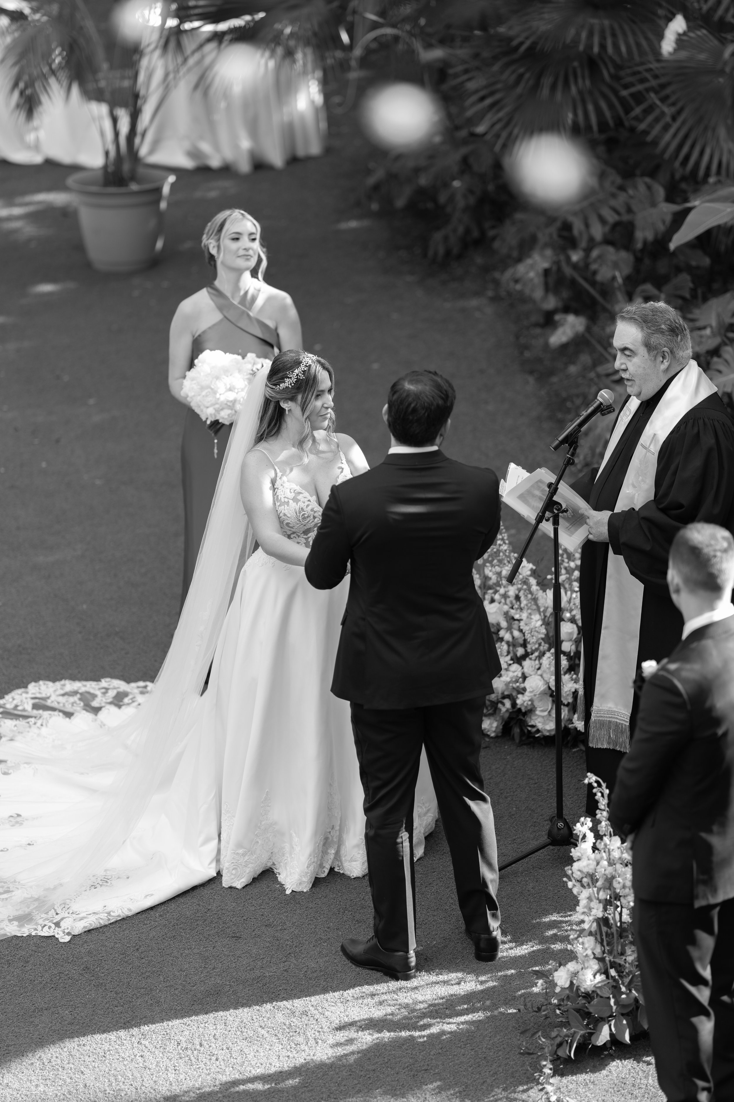 Romantic couple portrait during an outdoor wedding ceremony at Villa Woodbine with pink bougainvillea; fine art photography by Star Visual Art, Miami.
