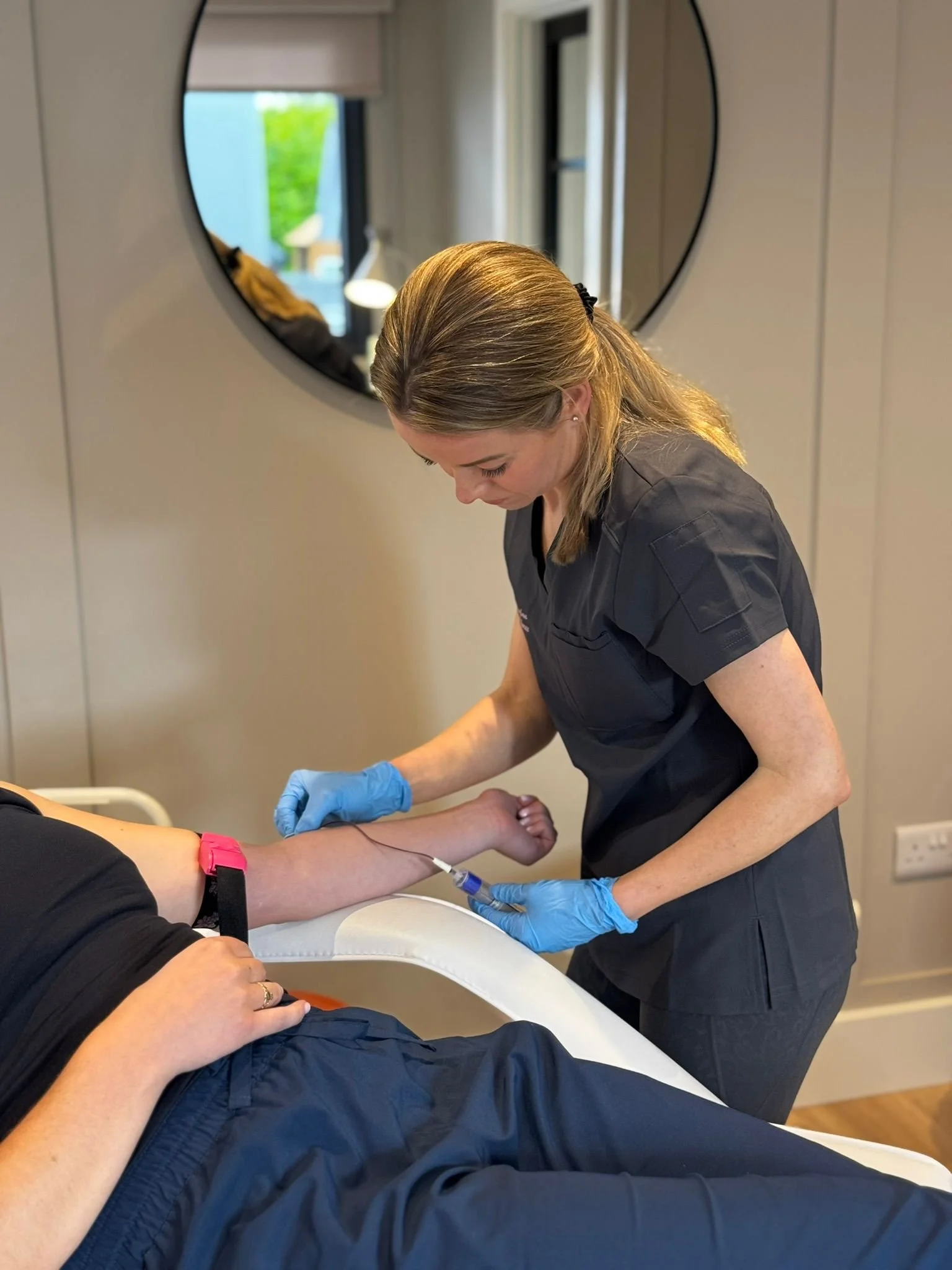 Healthcare worker administering an injection to a patient in a medical office.