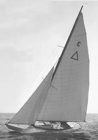 A sailboat with a large sail numbered 3, sailing on the water with a partly cloudy sky.