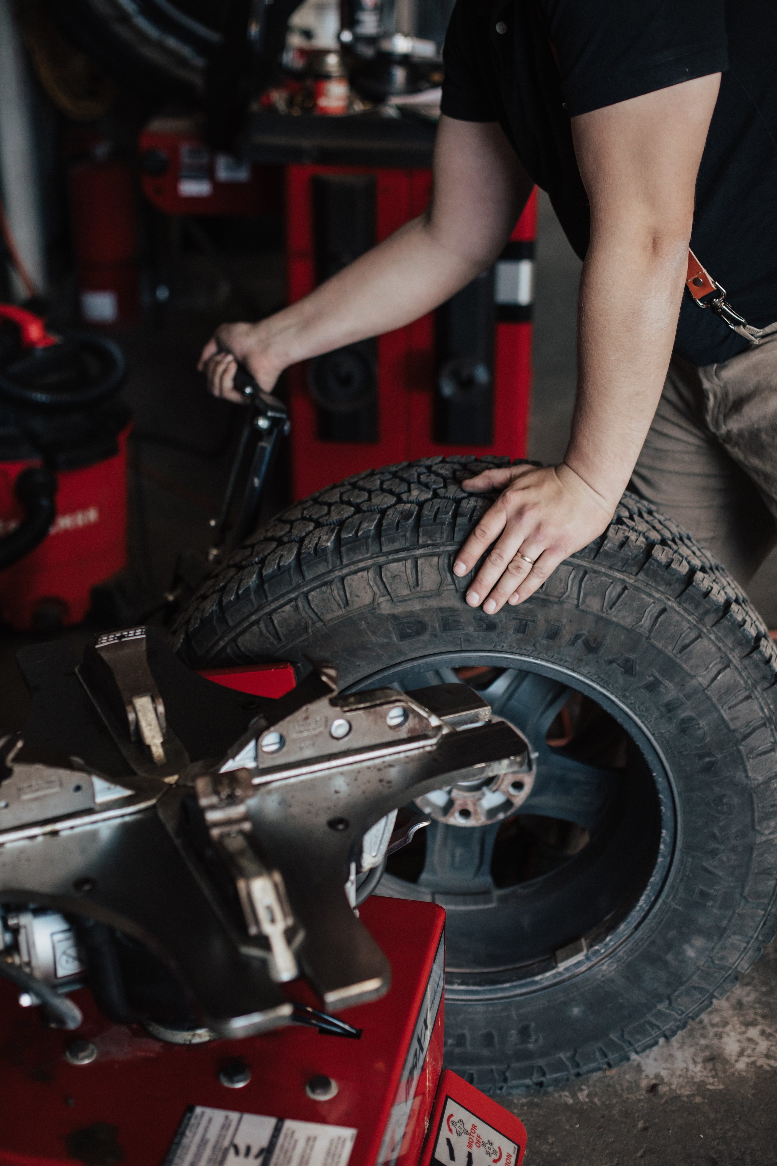 Person replacing a tire on a car in a garage.
