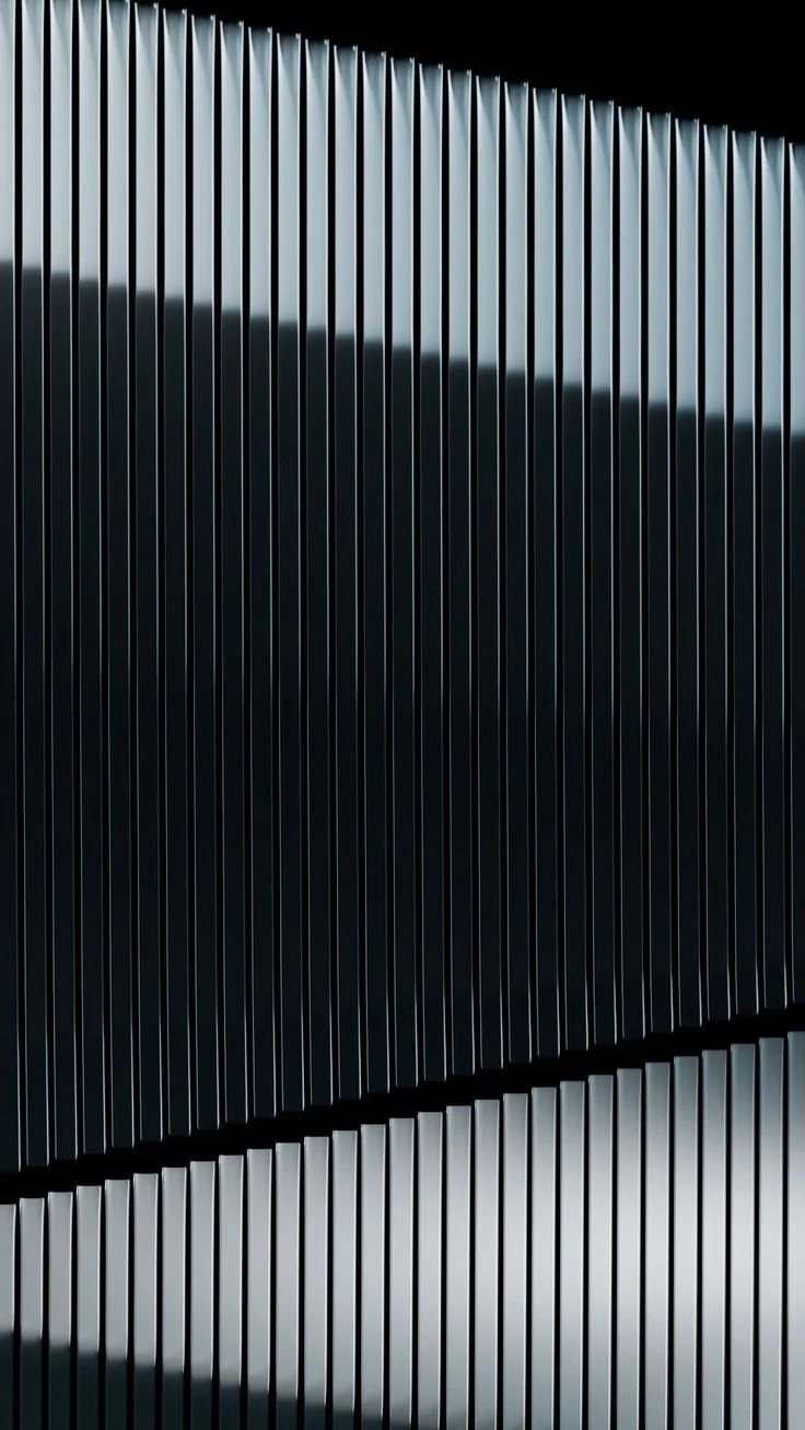 Close-up of metallic vertical slats forming a modern architectural facade in black and gray tones.