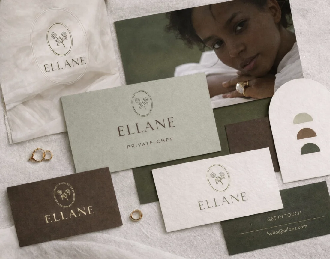 Flat lay of branding materials including cards with the text "ELLANE," rings, and a photograph of a woman with curly hair.