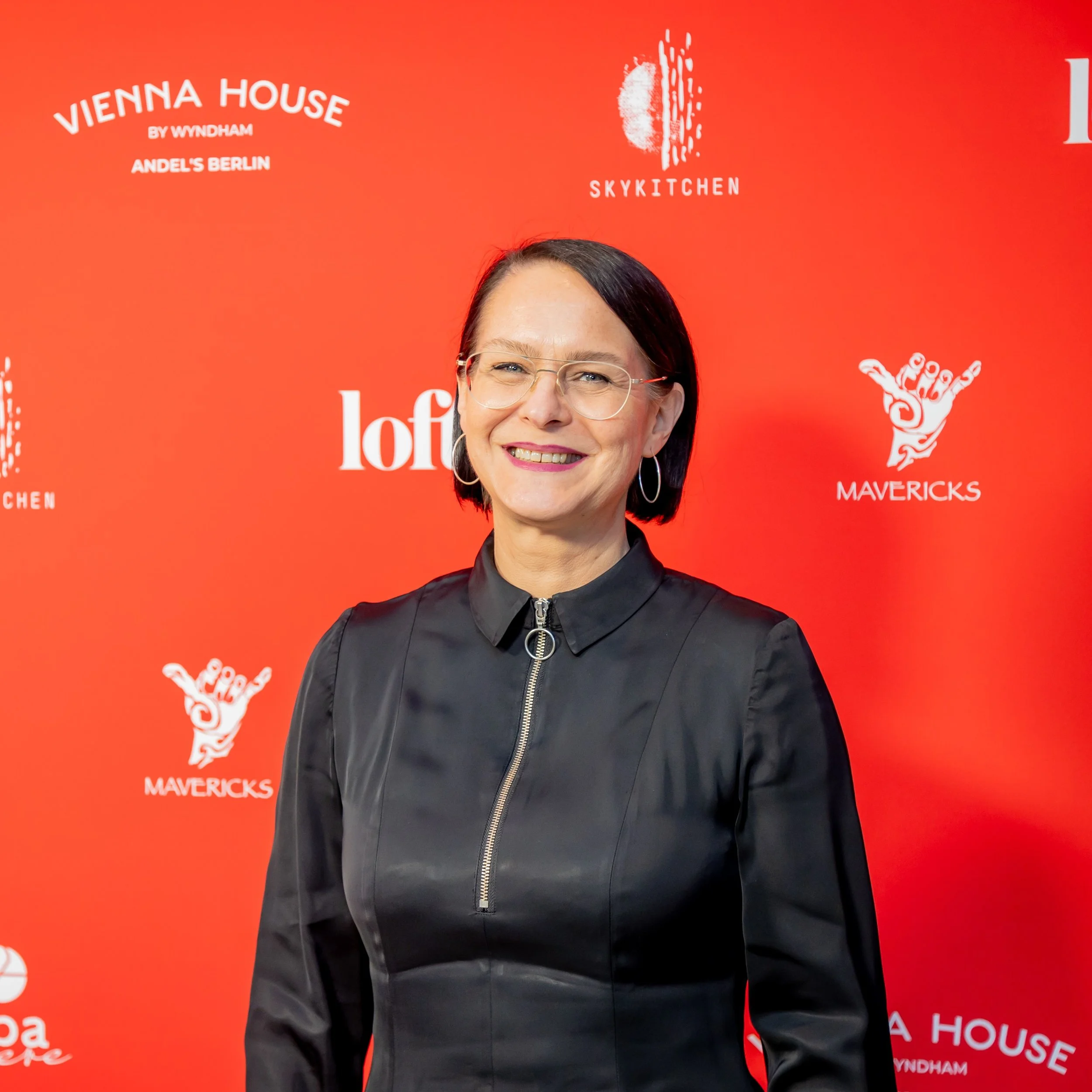 Janka Altmann at an event in front of a red wall
