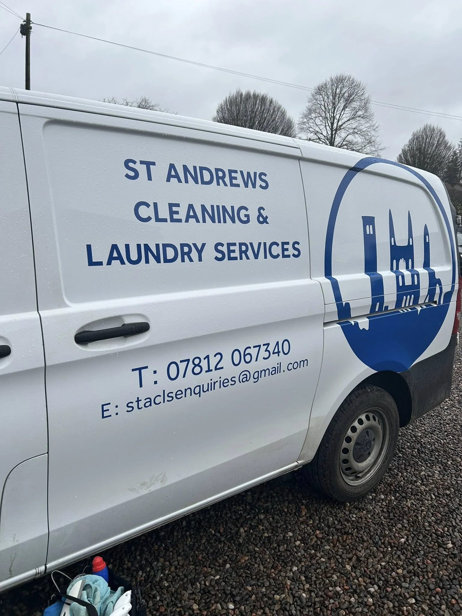 White van with blue text and logo advertising St Andrews Cleaning & Laundry Services. Contact information including phone number and email visible.