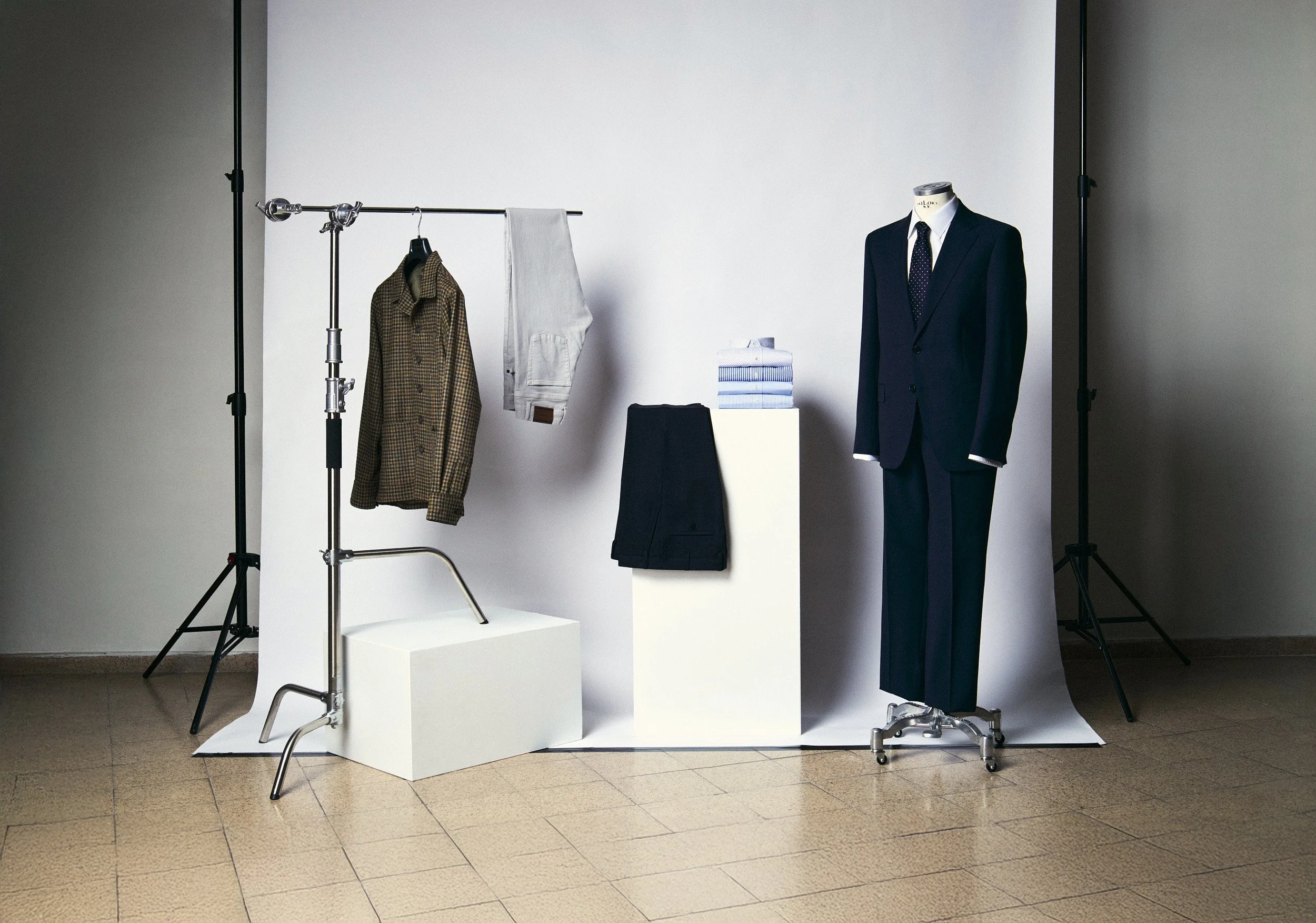 Fotografía de producto de camisas y trajes sobre un fondo blanco en un estudio fotográfico.