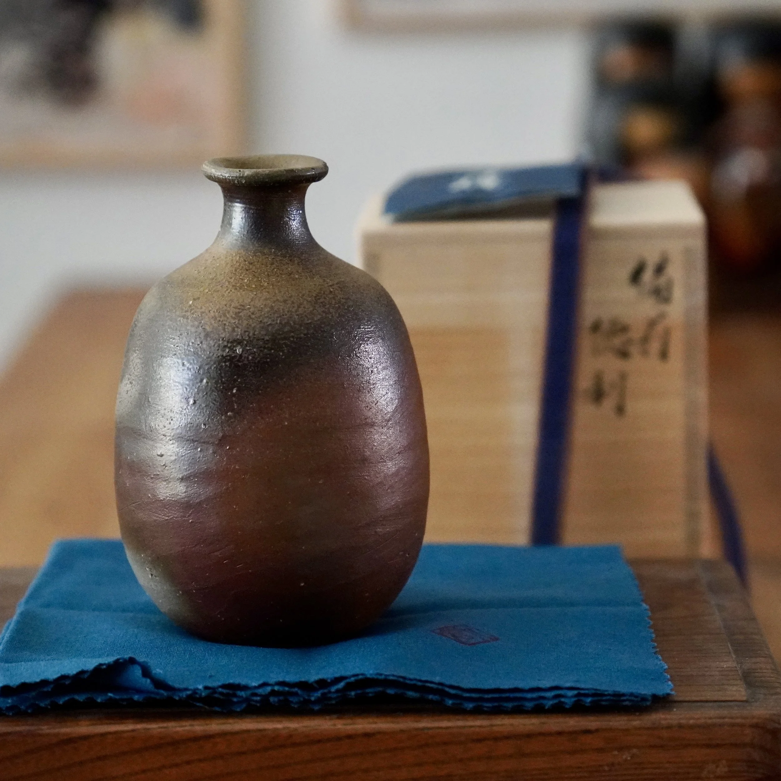 Bizen-yaki tokkuri, slightly turned, showing the deep reddish brown tones on the lower body