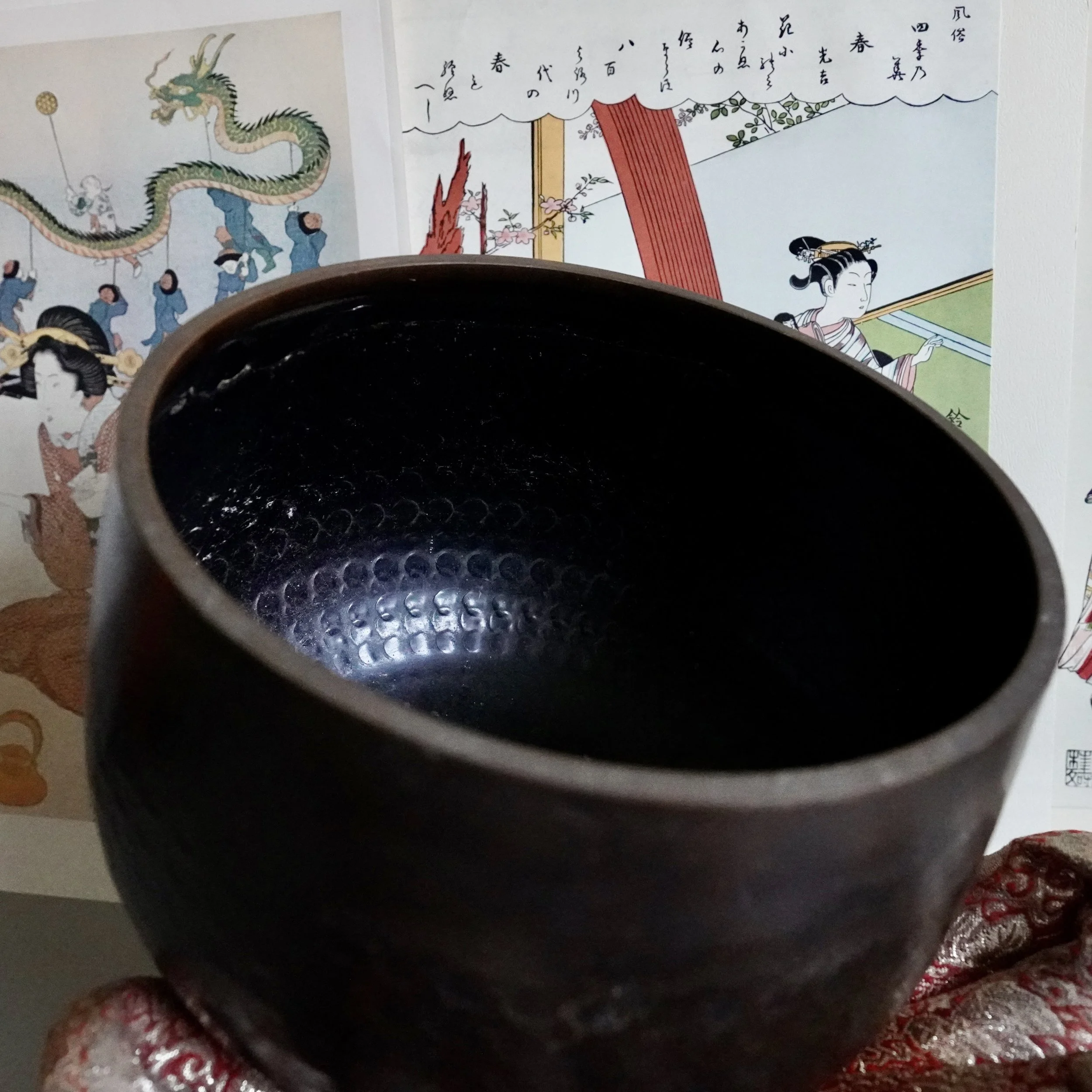 Interior of signed Tsutsumi orin, Japanese bronze singing bowl, showing hammered texture and dark patina