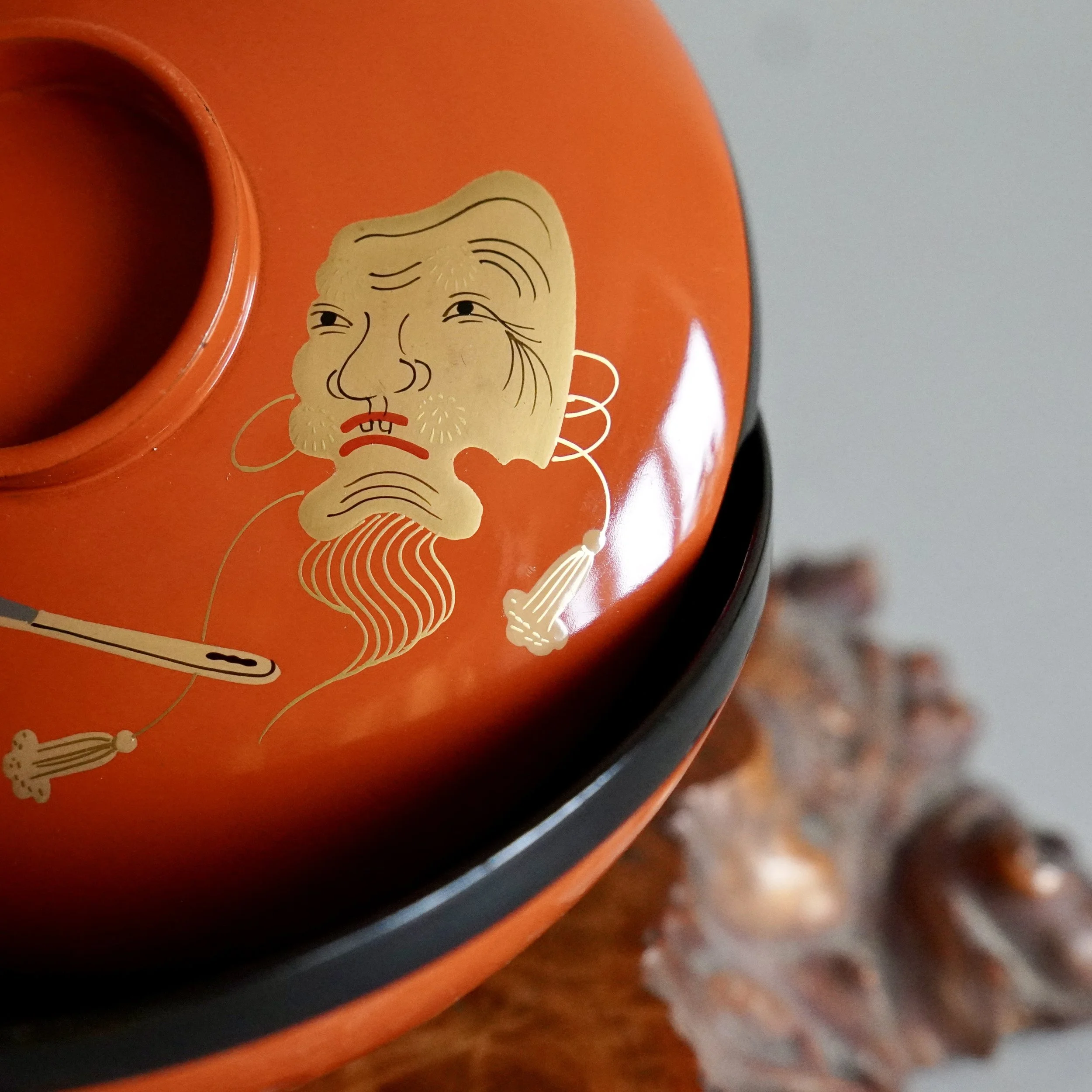 A vermillion red urushi lacquerware owan bowl set from the late Meiji period, decorated with a detailed gold maki-e hand-painted Okina mask signature.