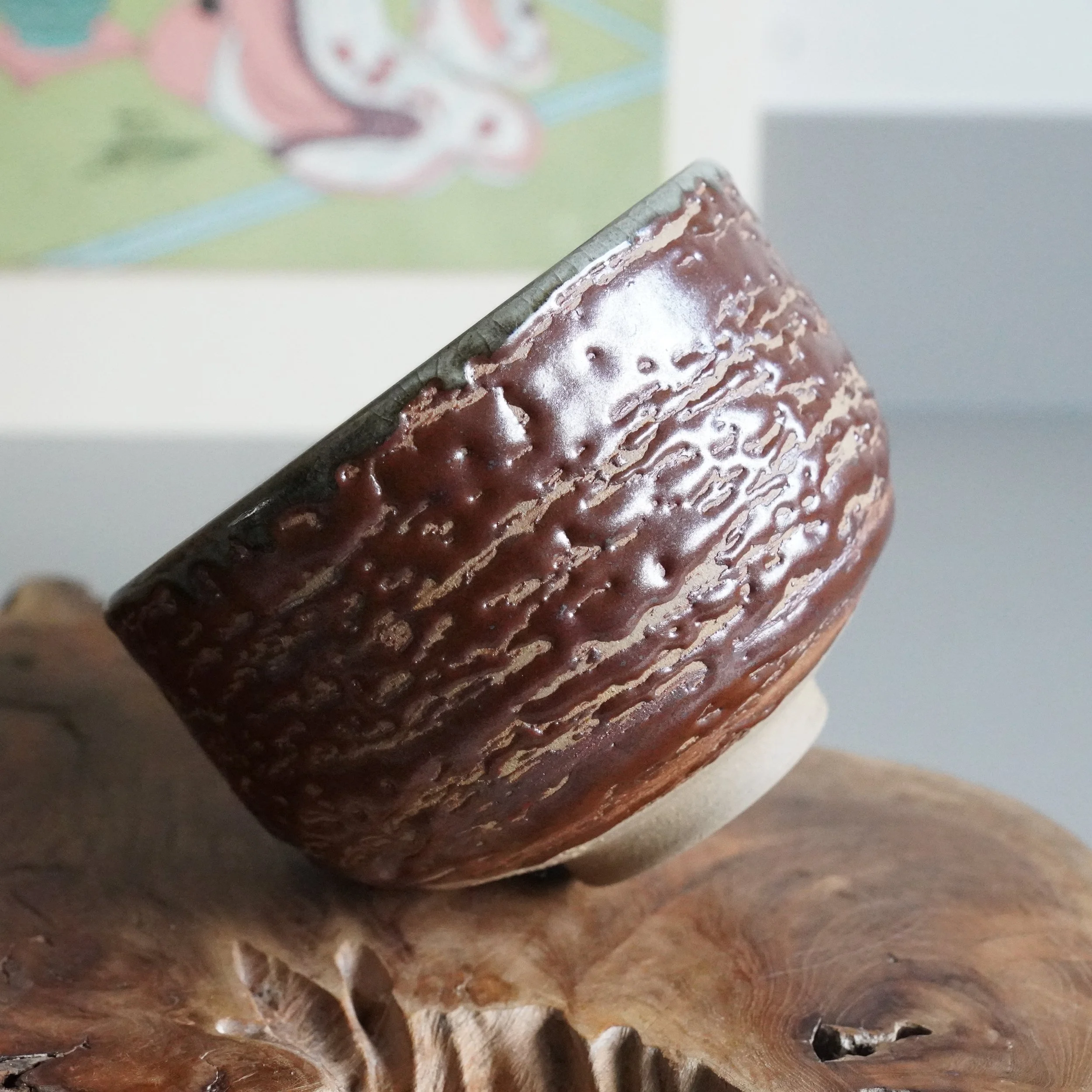 Inuyama-yaki chawan tilted to show grey-green interior against brown matsukawa glaze exterior