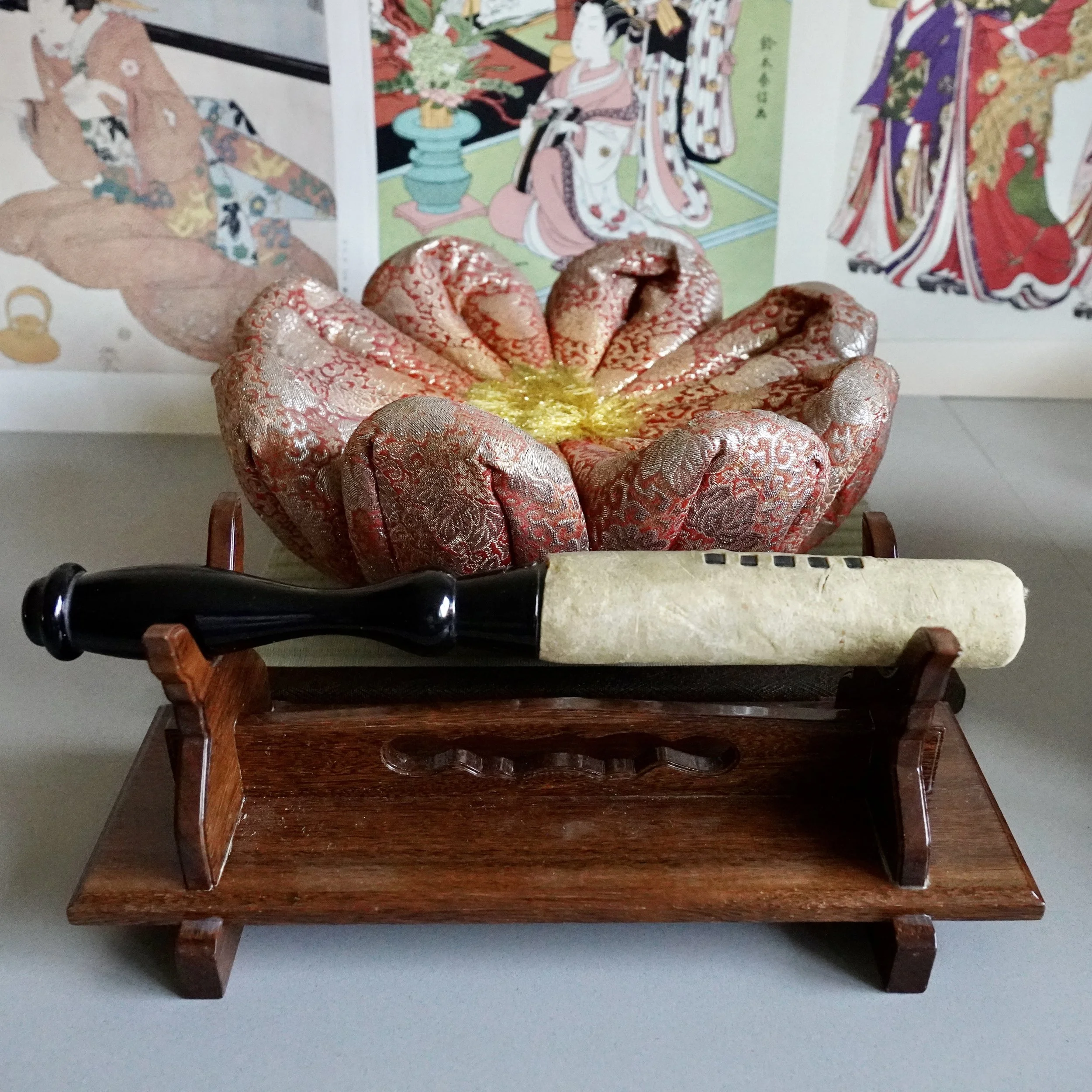 Brocade cushion and striker resting on wooden stand for Japanese orin singing bowl