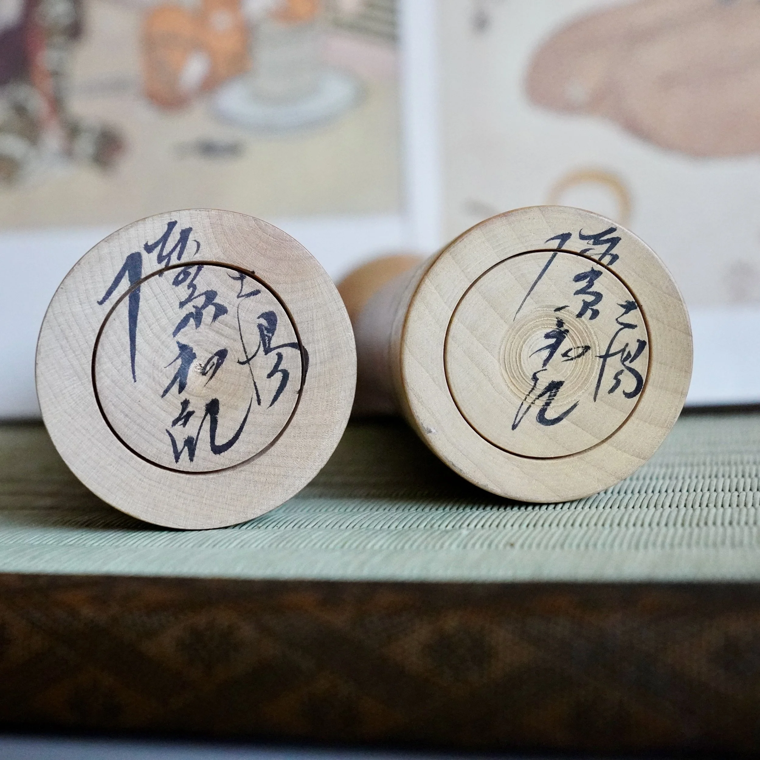 Signed kokeshi doll bases, cursive Japanese calligraphy by maker Jinnohara Kazunori.