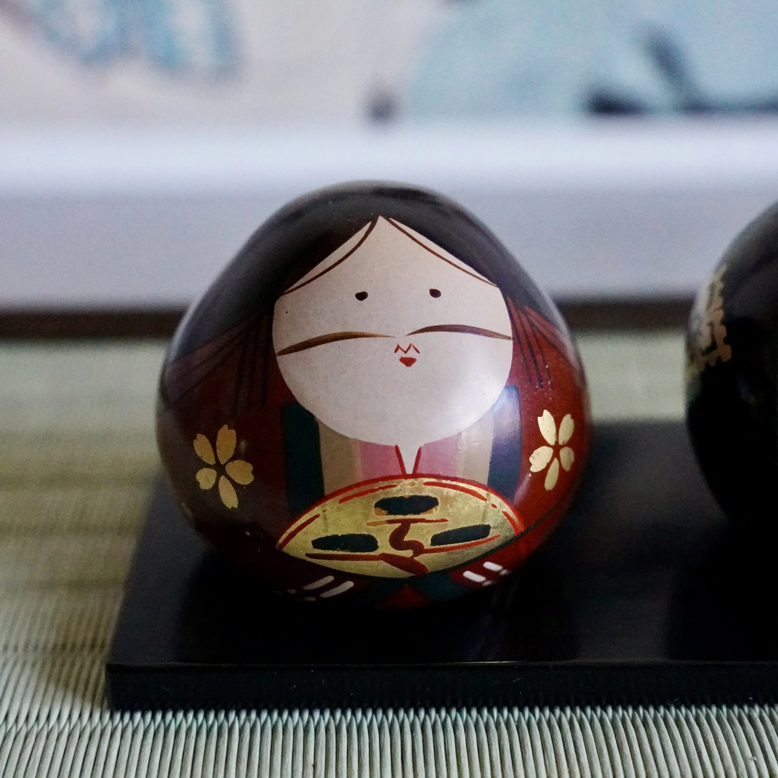 Ouchi-nuri bride hina doll close-up, gold sakura blossoms and miniature fan detail