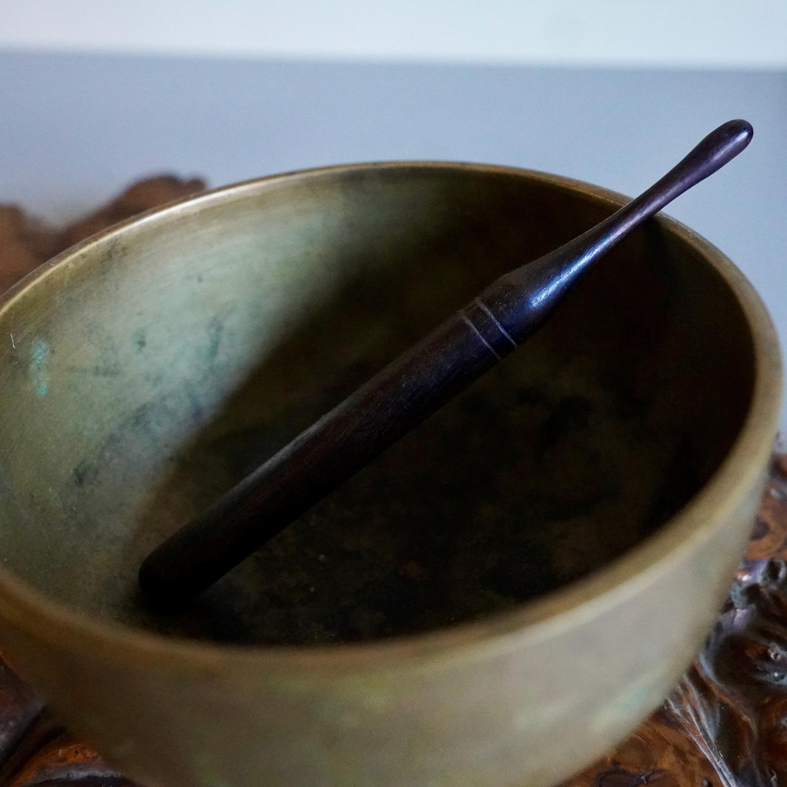 Bronze orin bowl interior with wooden striker resting inside