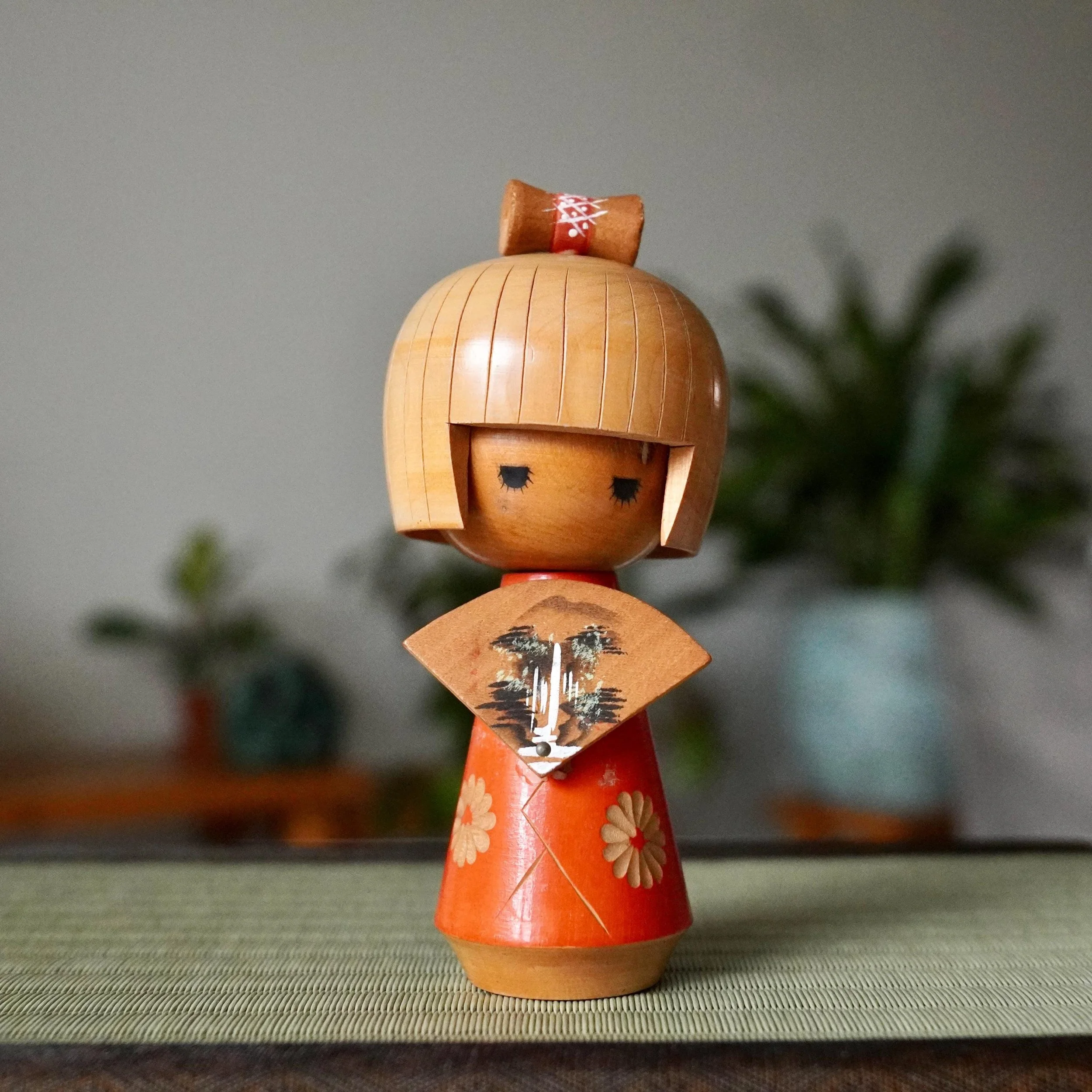 Sōsaku kokeshi with fan motif signed Tanaka Kojo 田中晃常 painted decoration, Shōwa period 1960s Japan displayed on tatamimat