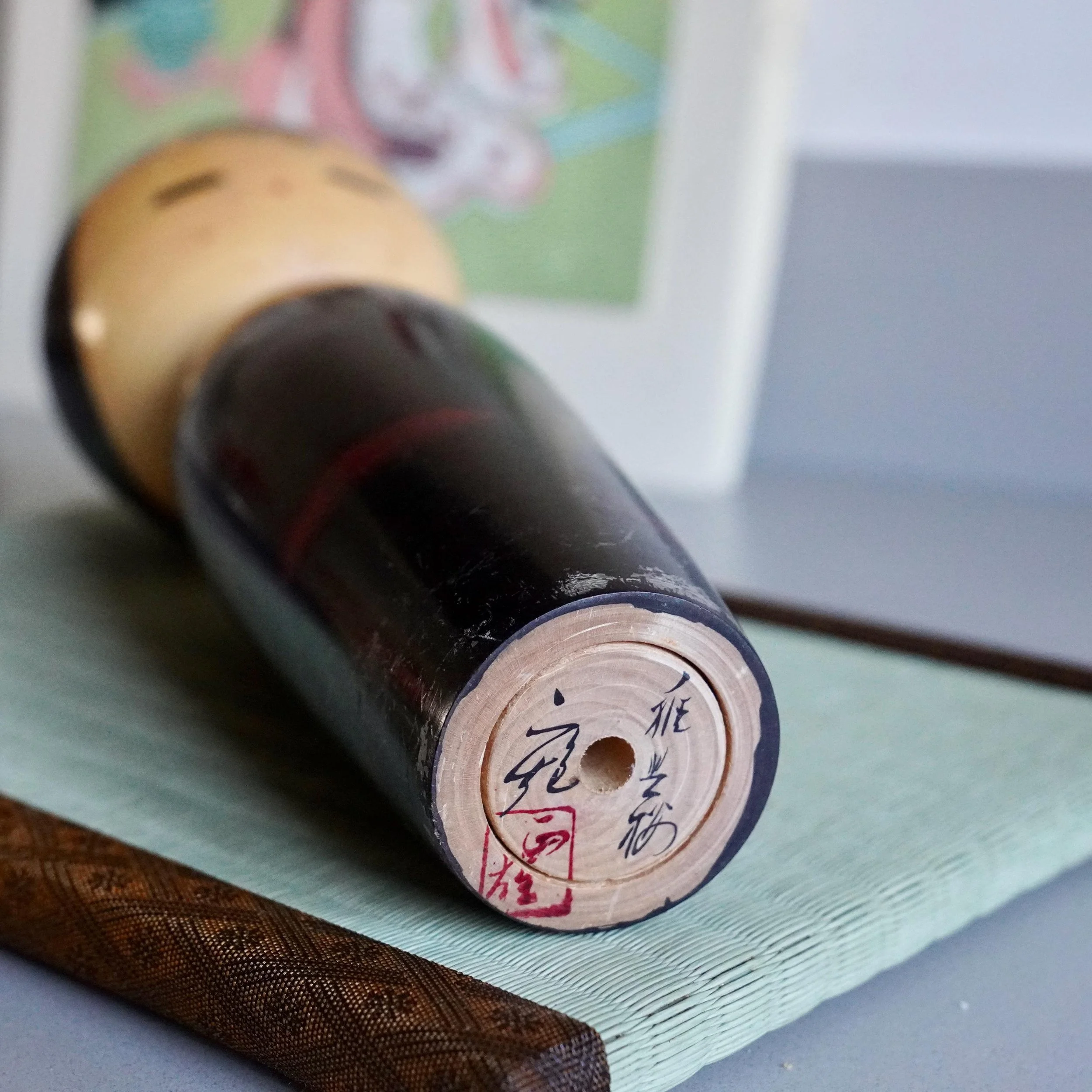 Base of Watanabe Masao sosaku kokeshi showing brush signature and red seal stamp