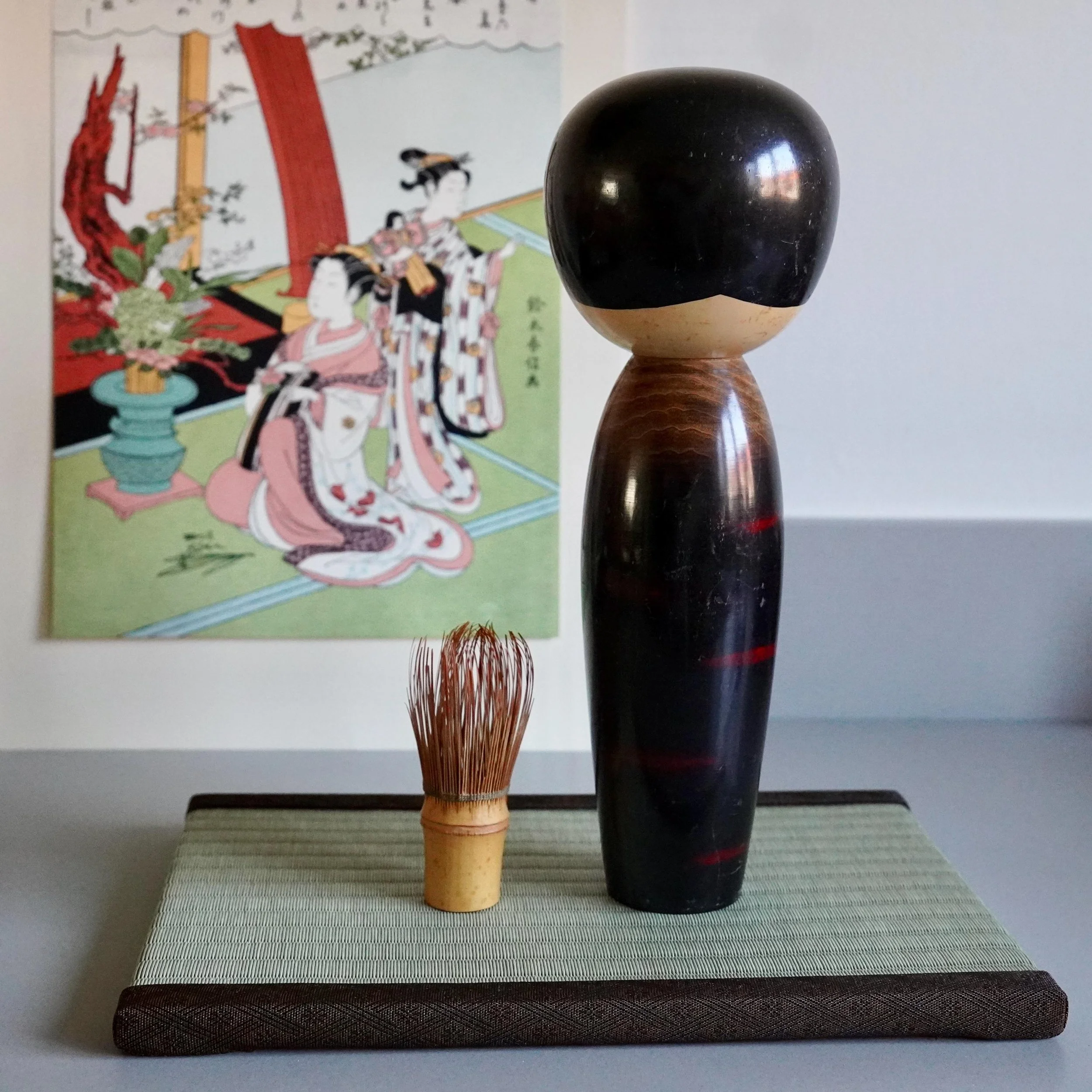 Back view of Watanabe Masao sosaku kokeshi, dark lacquered trunk with red grain streaks