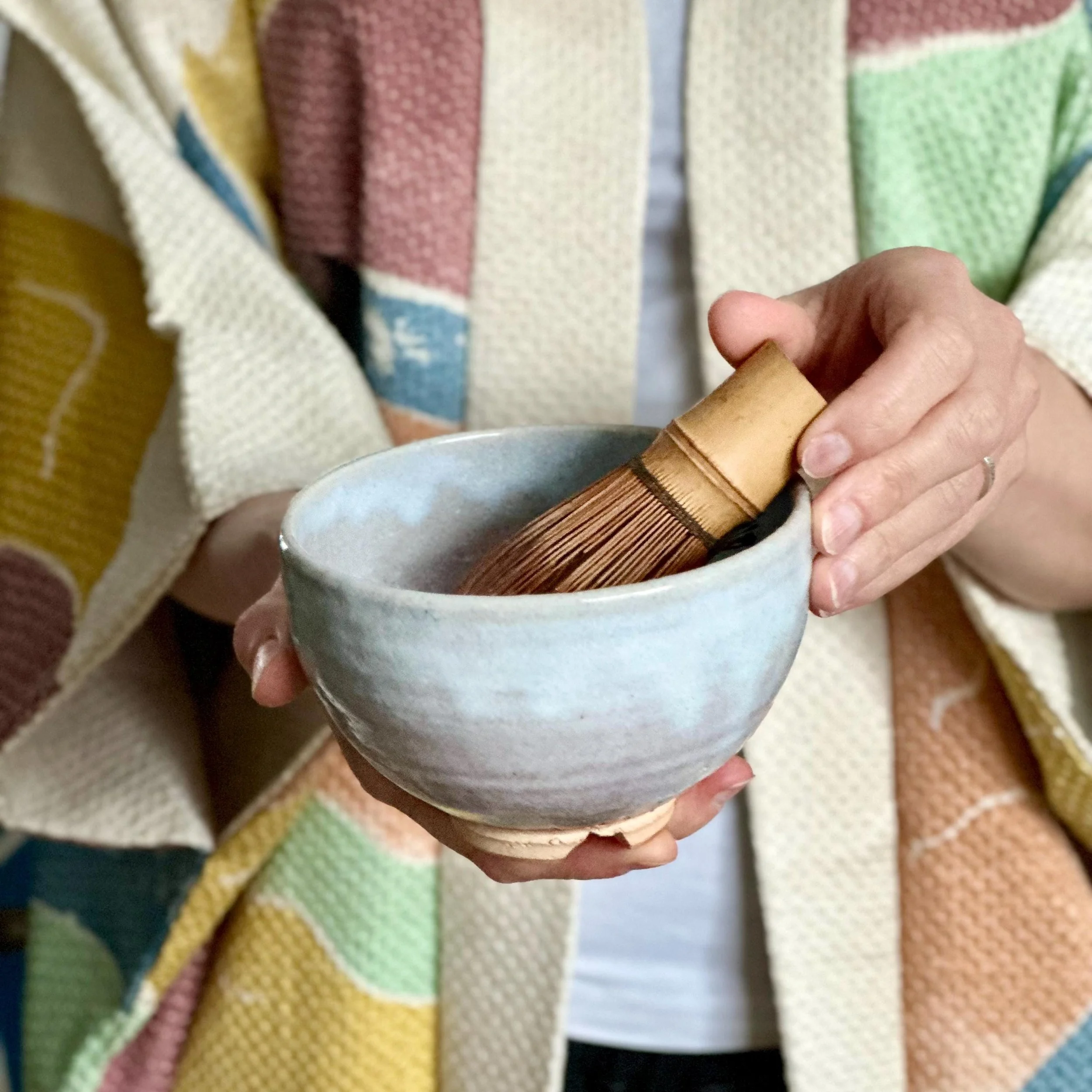 Hagi-yaki chawan Moriwaki Fumitada warikodai foot warm white glaze with signed tomobako, Shōwa period Japan, held in hands by woman wearing haori with matcha whisk in chawan