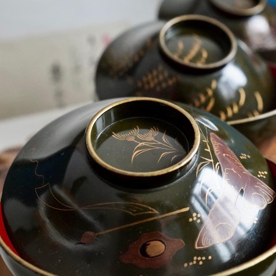 Set of 3 wooden urushi green owan with maki-e decoration, different motif on each bowl, late Taishō to early Shōwa period