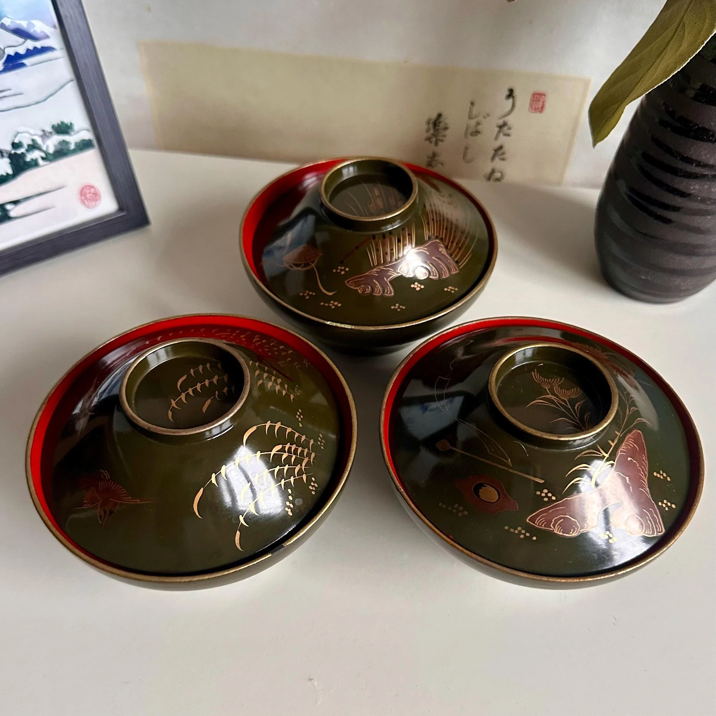 Set of 3 wooden urushi green owan with maki-e decoration, different motif on each bowl, late Taishō to early Shōwa period