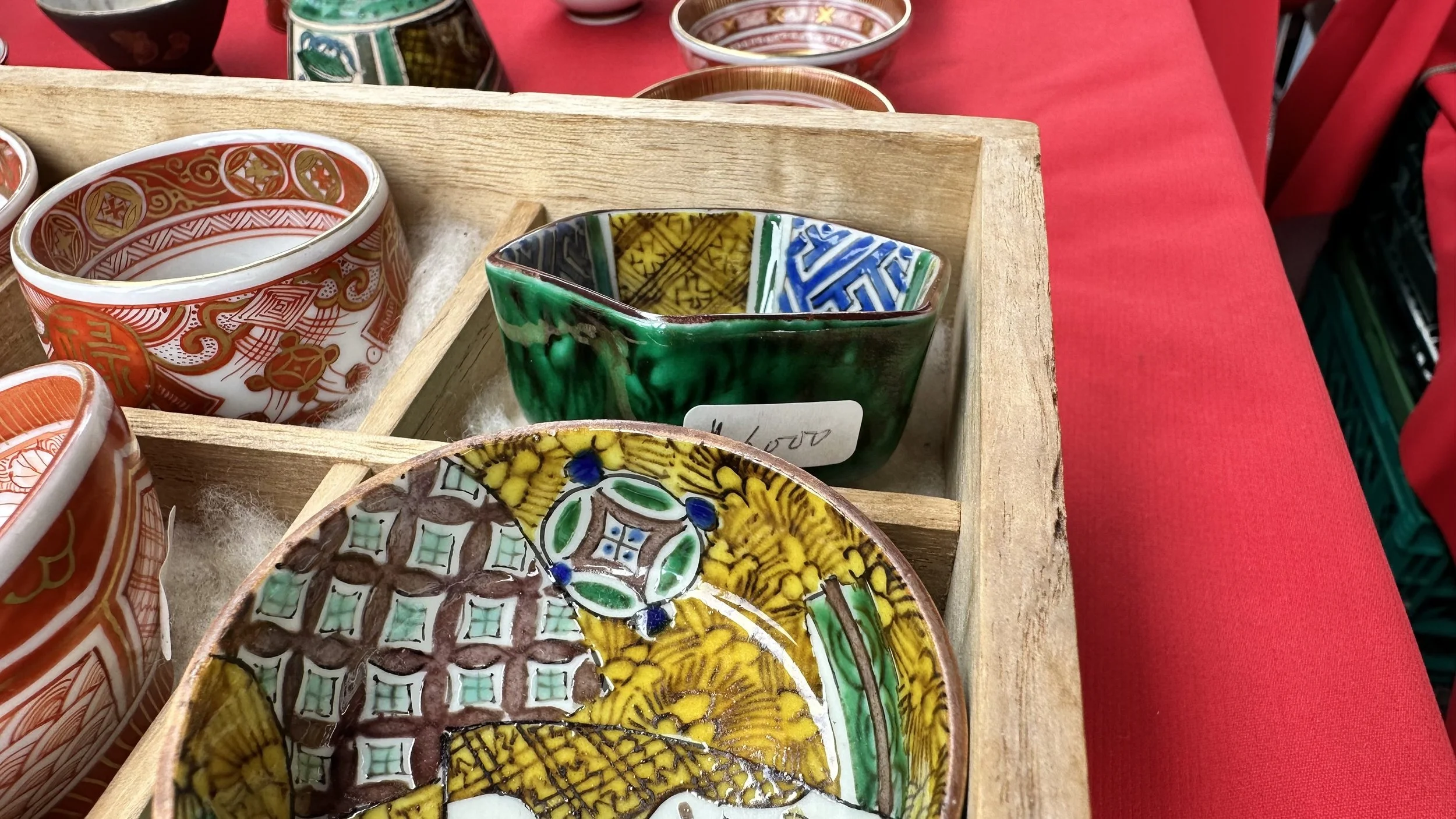 Hand-painted Japanese ceramic bowls in a wooden crate