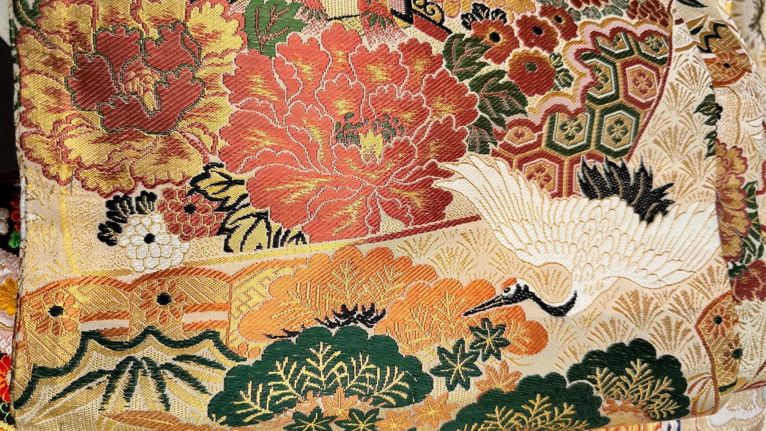 Close-up of vintage Japanese brocade silk obi belt with crane and peony motif